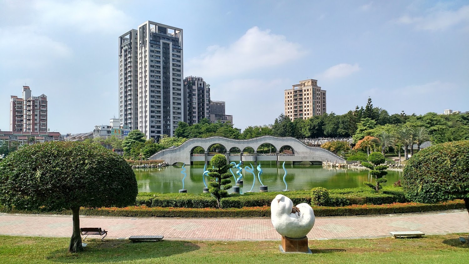 豐樂雕塑公園湖景拱橋與城市天際線