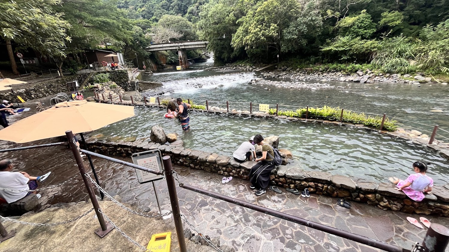 宇內溪戶外溫泉足浴池與後方溪流橋景