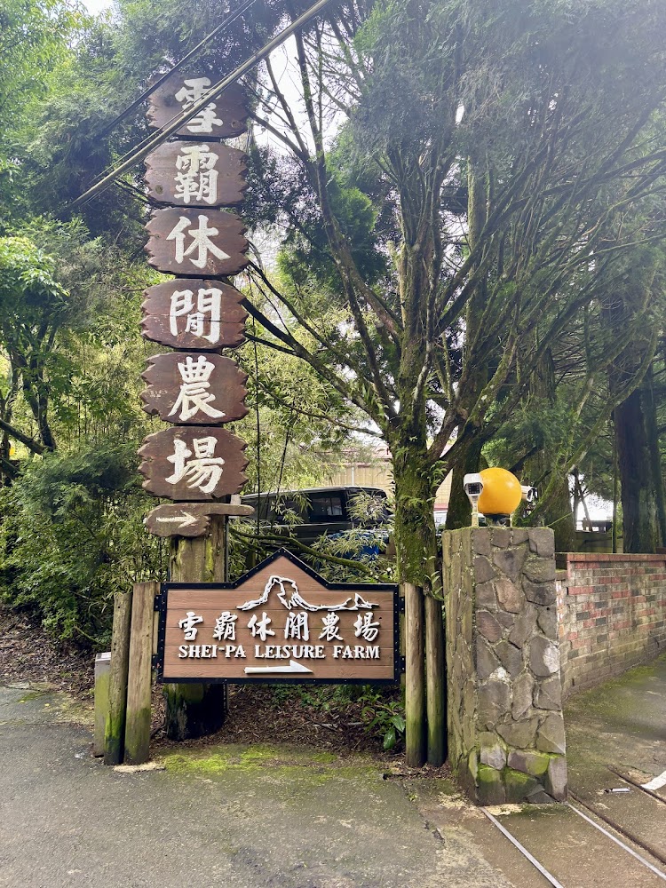 雪霸休閒農場入口木製招牌與綠樹環繞景象