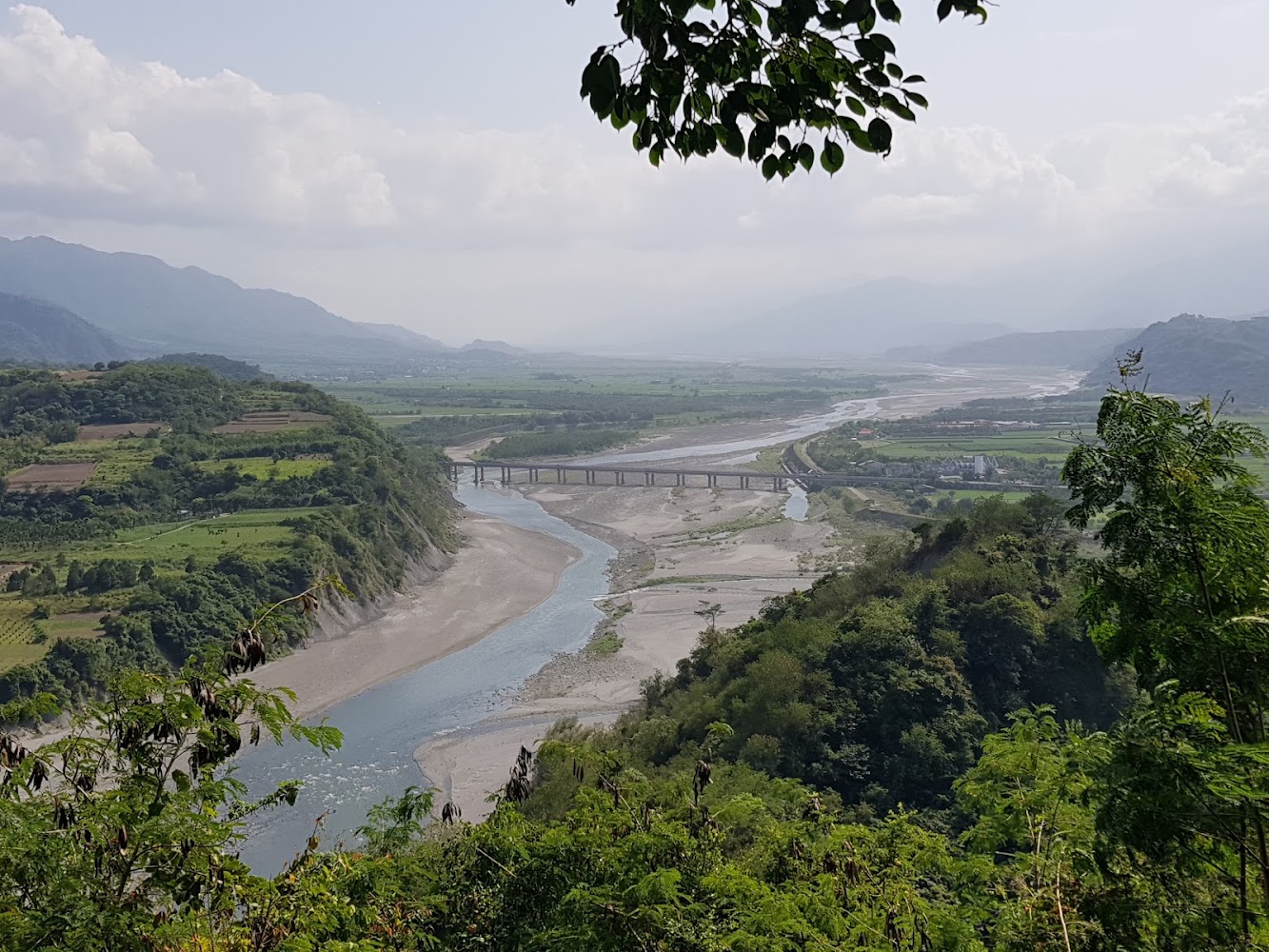 大河貫穿平原並有橋樑橫跨，周圍是山林與田野