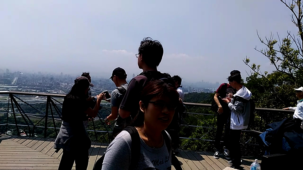 多位遊客站在觀景台上欣賞城市景觀