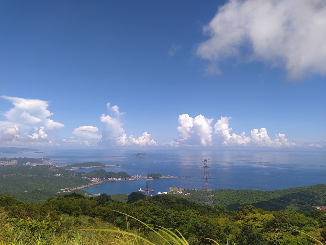 藍天大海與翠綠山丘景觀