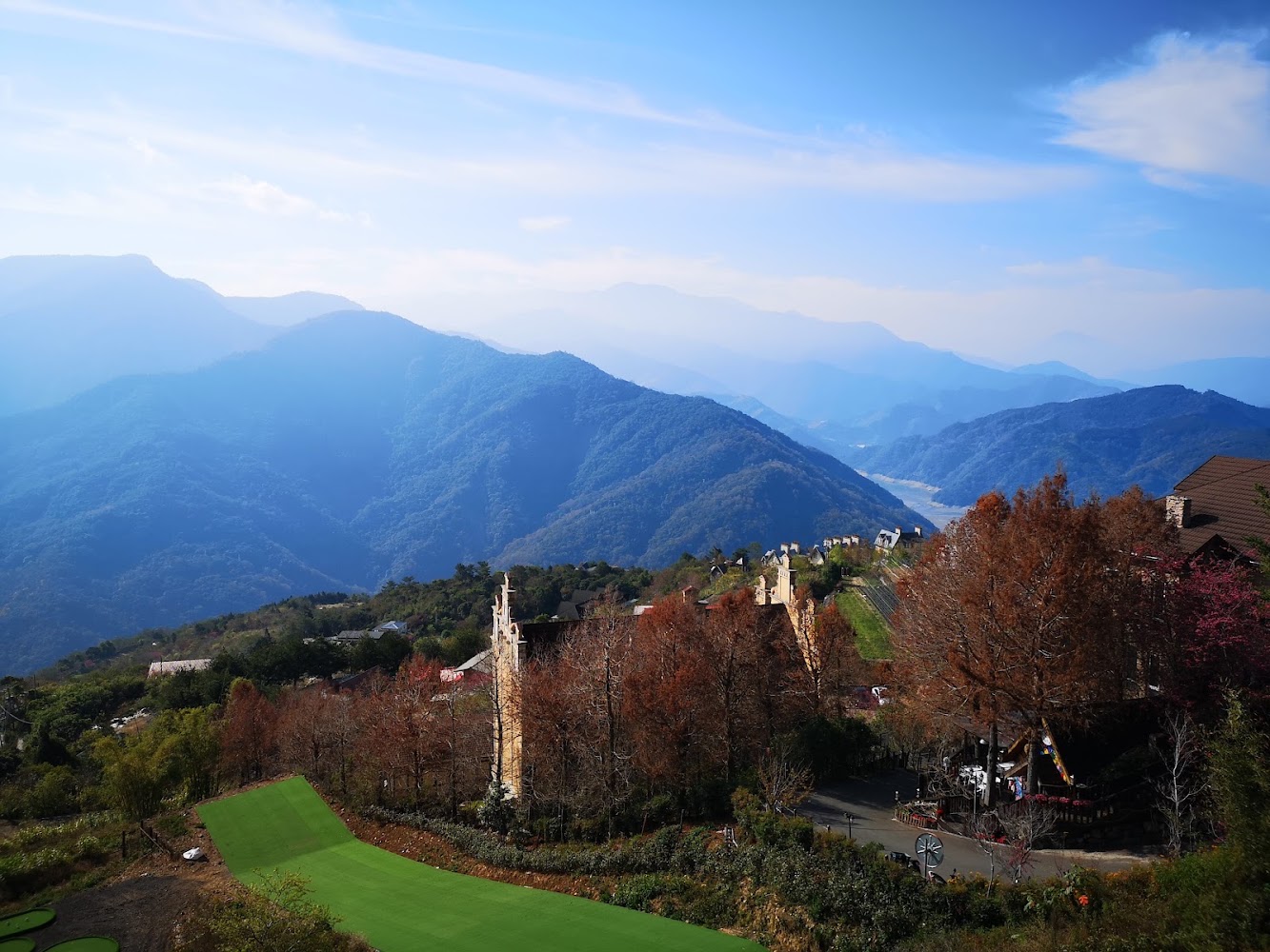 南投草地樹木與道路旁建築的優美山景