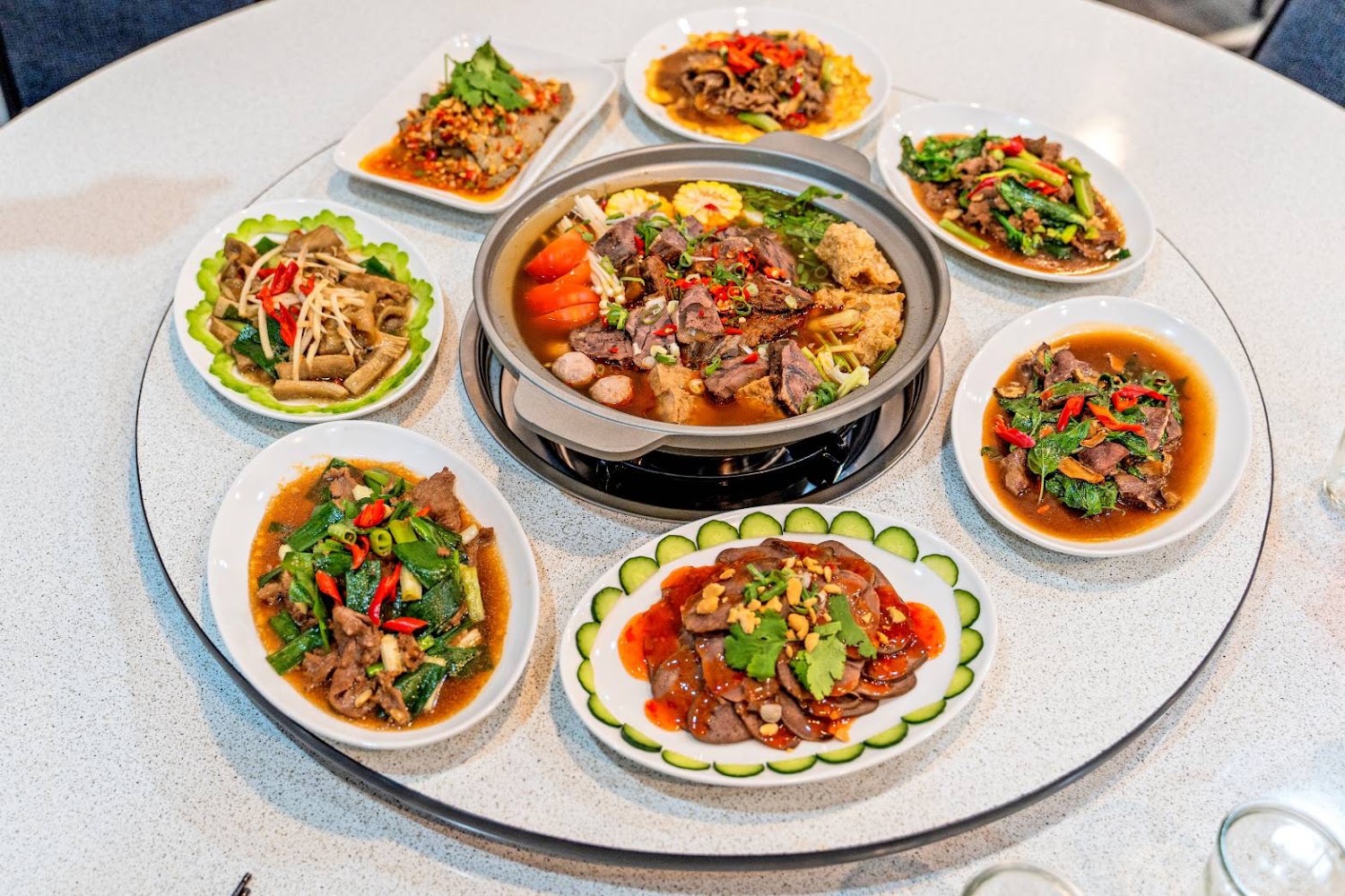 誠大牛肉店桌上擺滿牛肉火鍋與多盤熱炒小菜