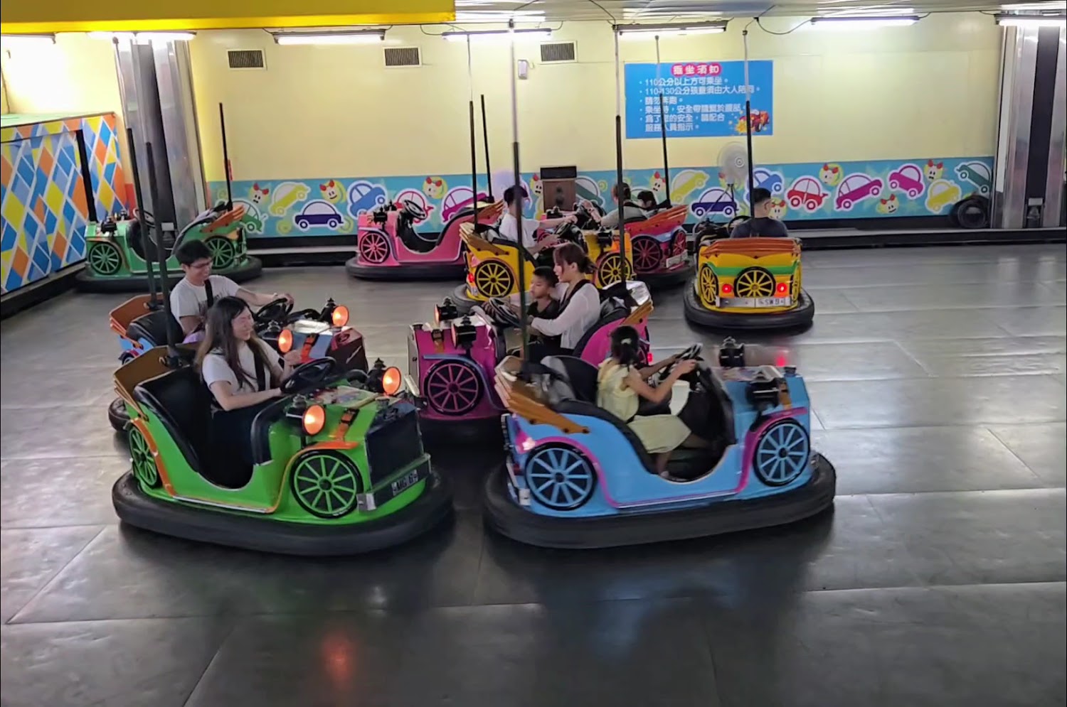 碰碰車遊樂場,許多大人和小孩正開心駕駛碰碰車