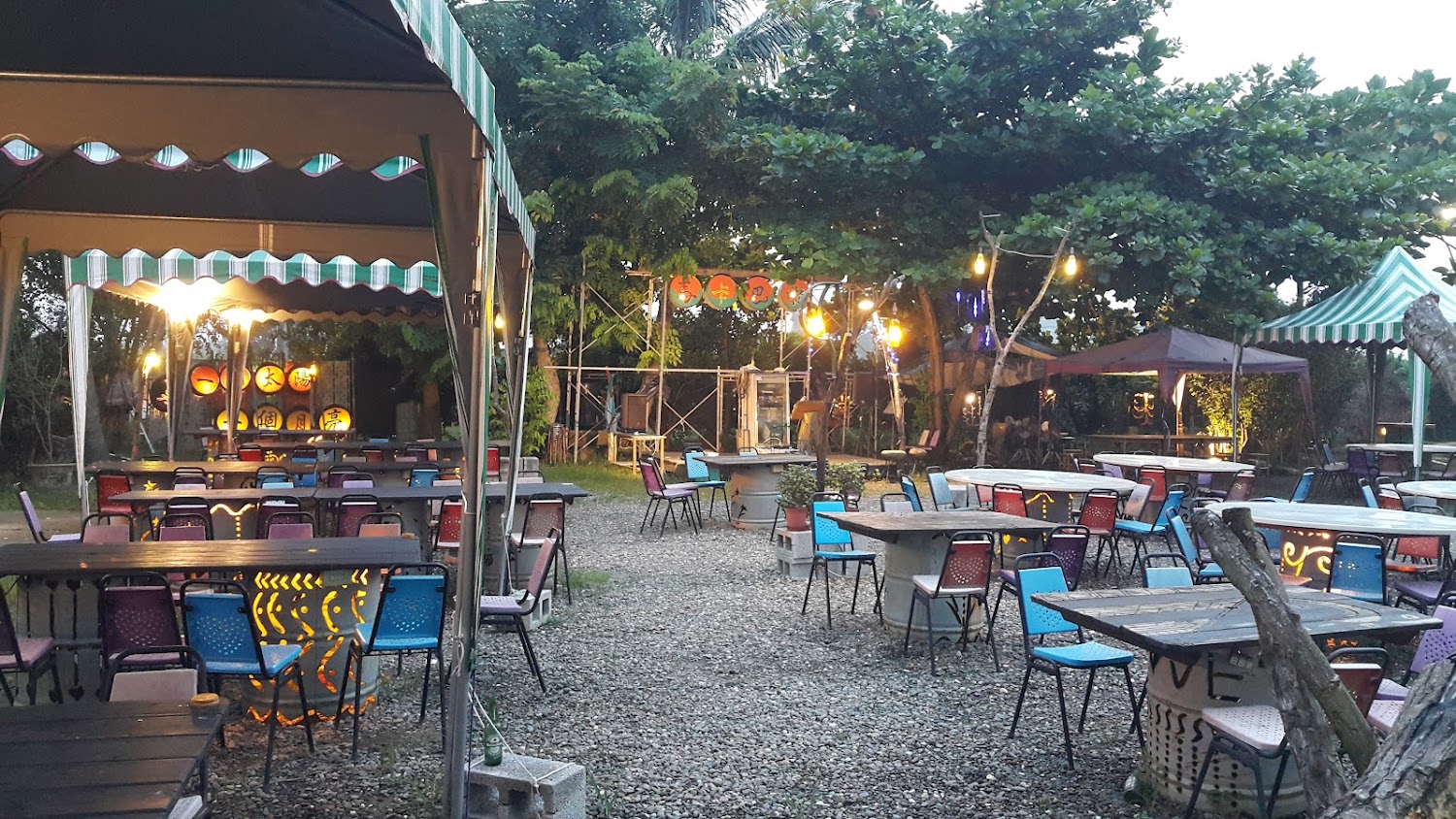 一個太陽一個月亮戶外用餐區有彩色椅子與帳篷區,氣氛休閒