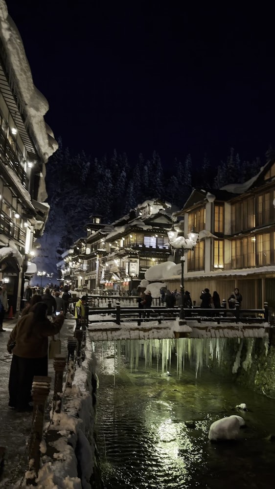 冬季夜晚銀山溫泉橋下冰柱與雪景