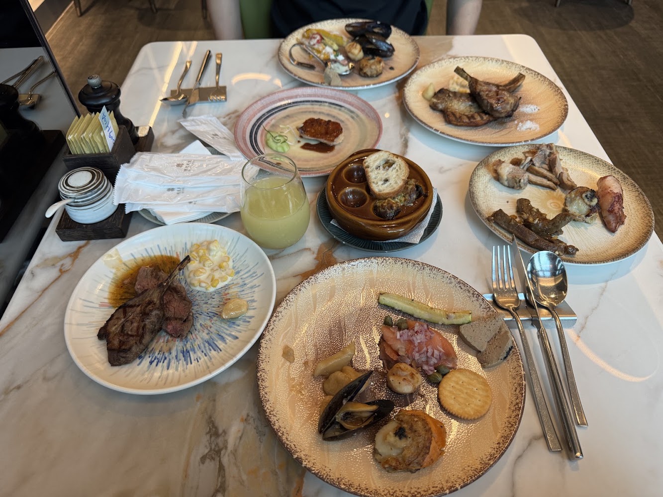 一桌豐富的西式餐食包括羊排海鮮冷盤與焗蝸牛