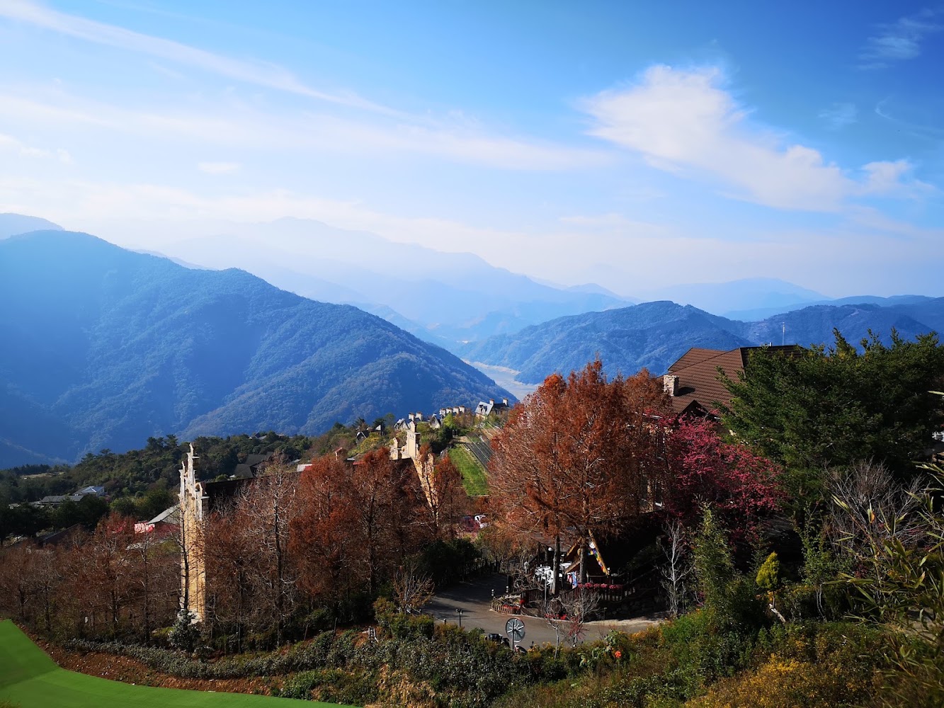南投紅葉樹與山坡建築的壯麗山景