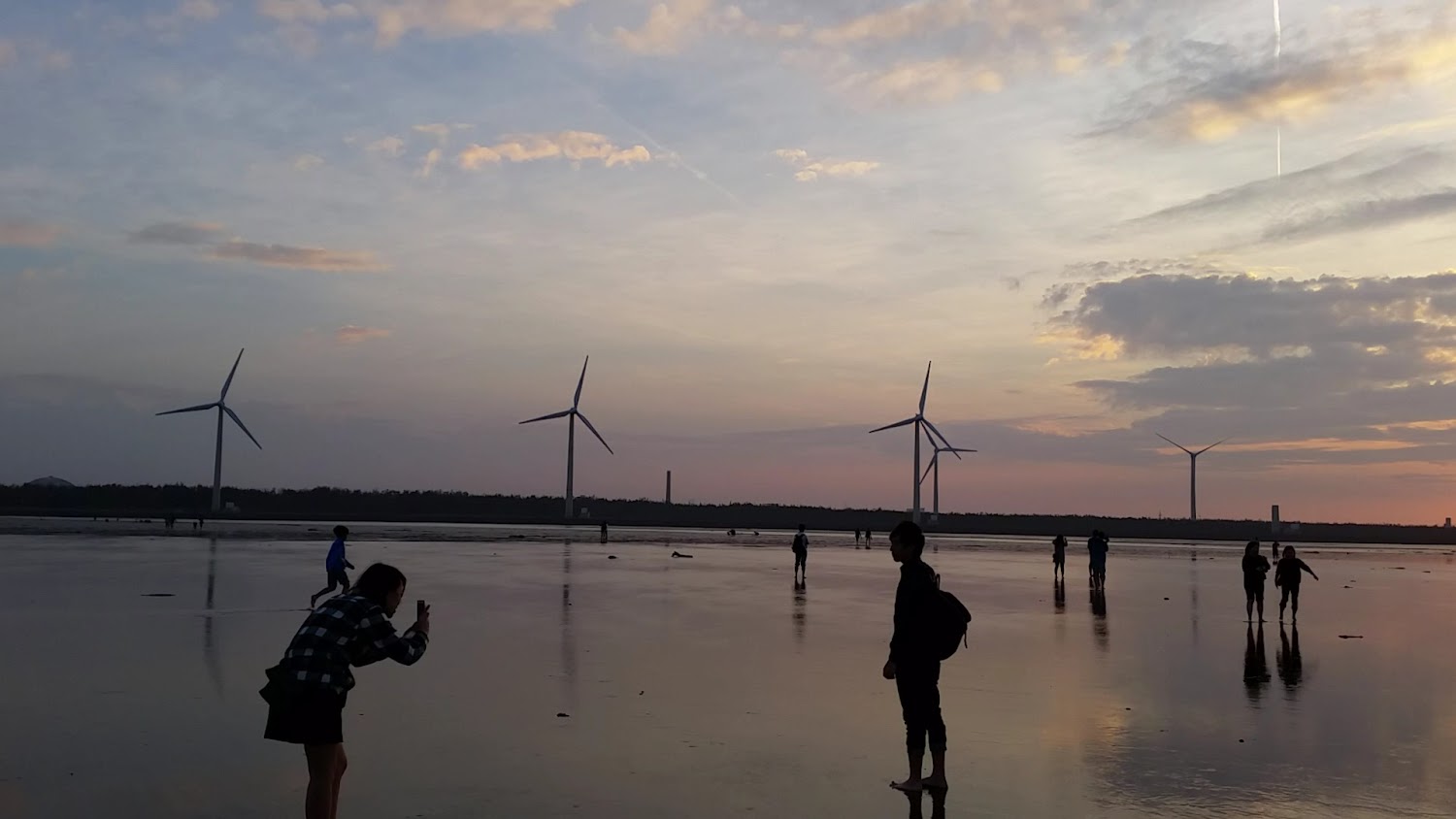 夕陽時分遊客在濕地散步拍照