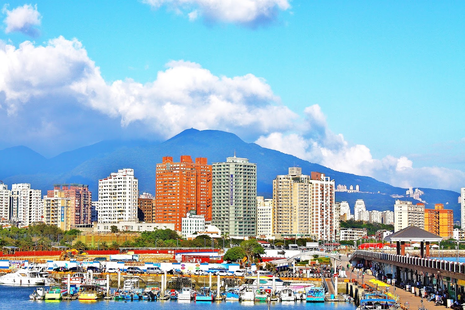 彩色高樓與港口船隻及山景