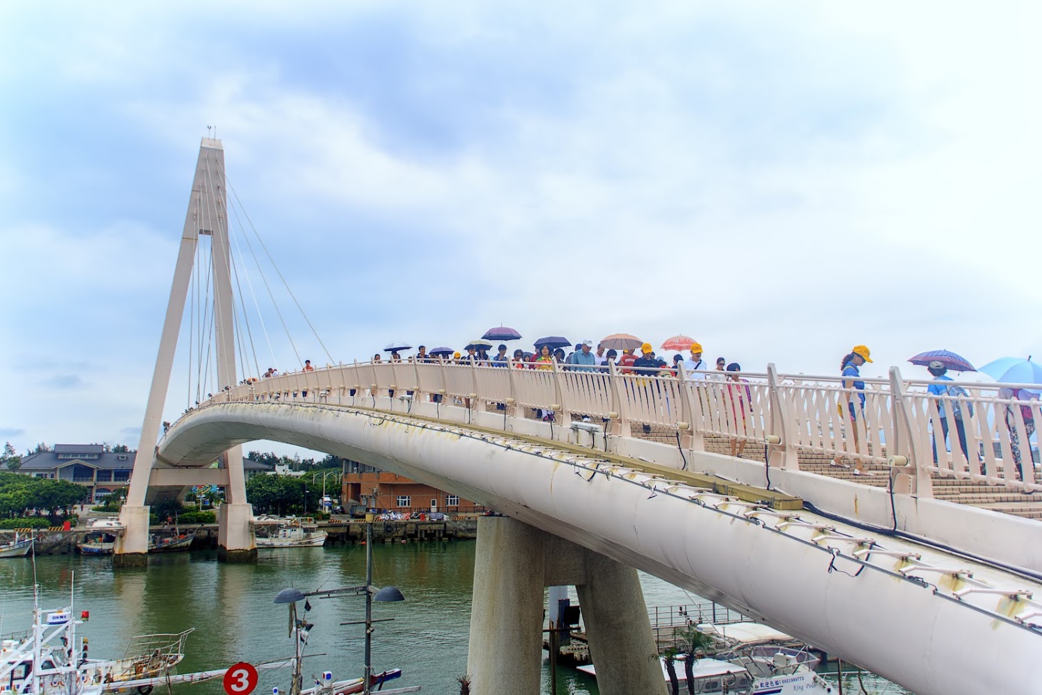 白色現代橋梁與水面漁船