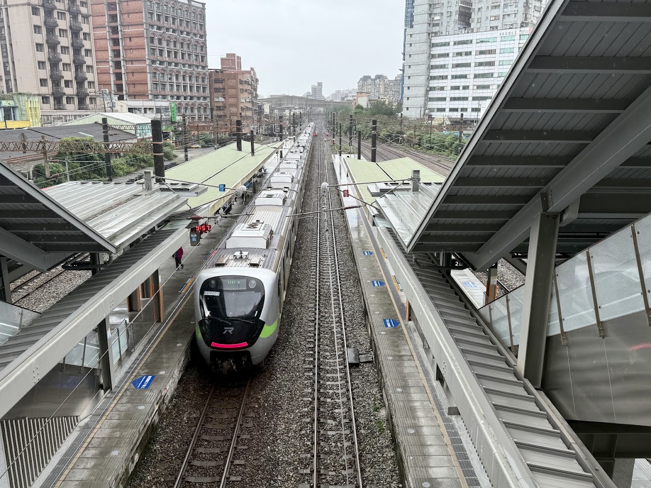 鶯歌車站月台與進站區間車，背景可見都市建築。