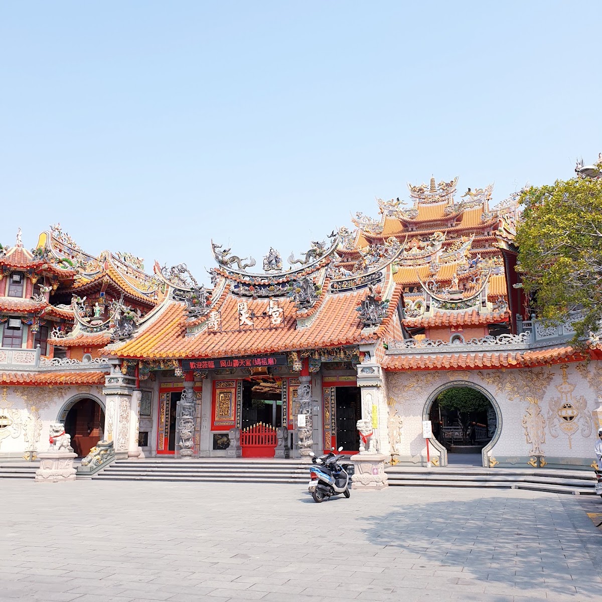 岡山壽天宮廟埕正面,屋頂剪黏交趾陶裝飾繁複,藍天白雲