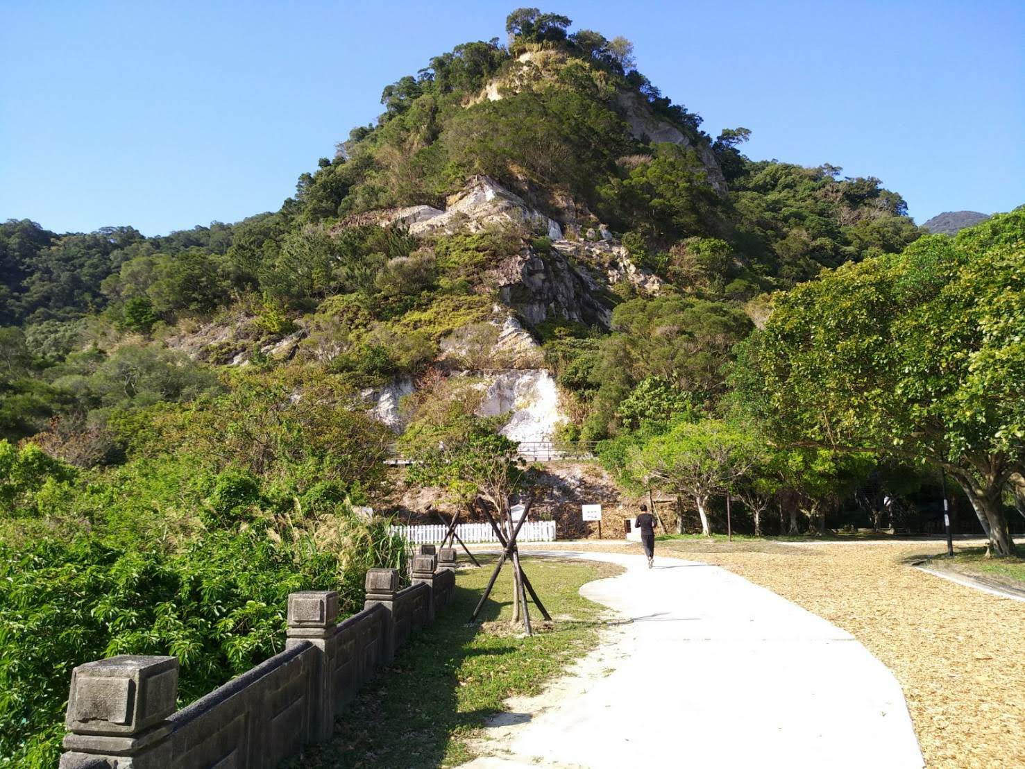 貴子坑水土保持教學園區五指山層露頭岩壁特寫，白色岩層裸露，前方為園區步道