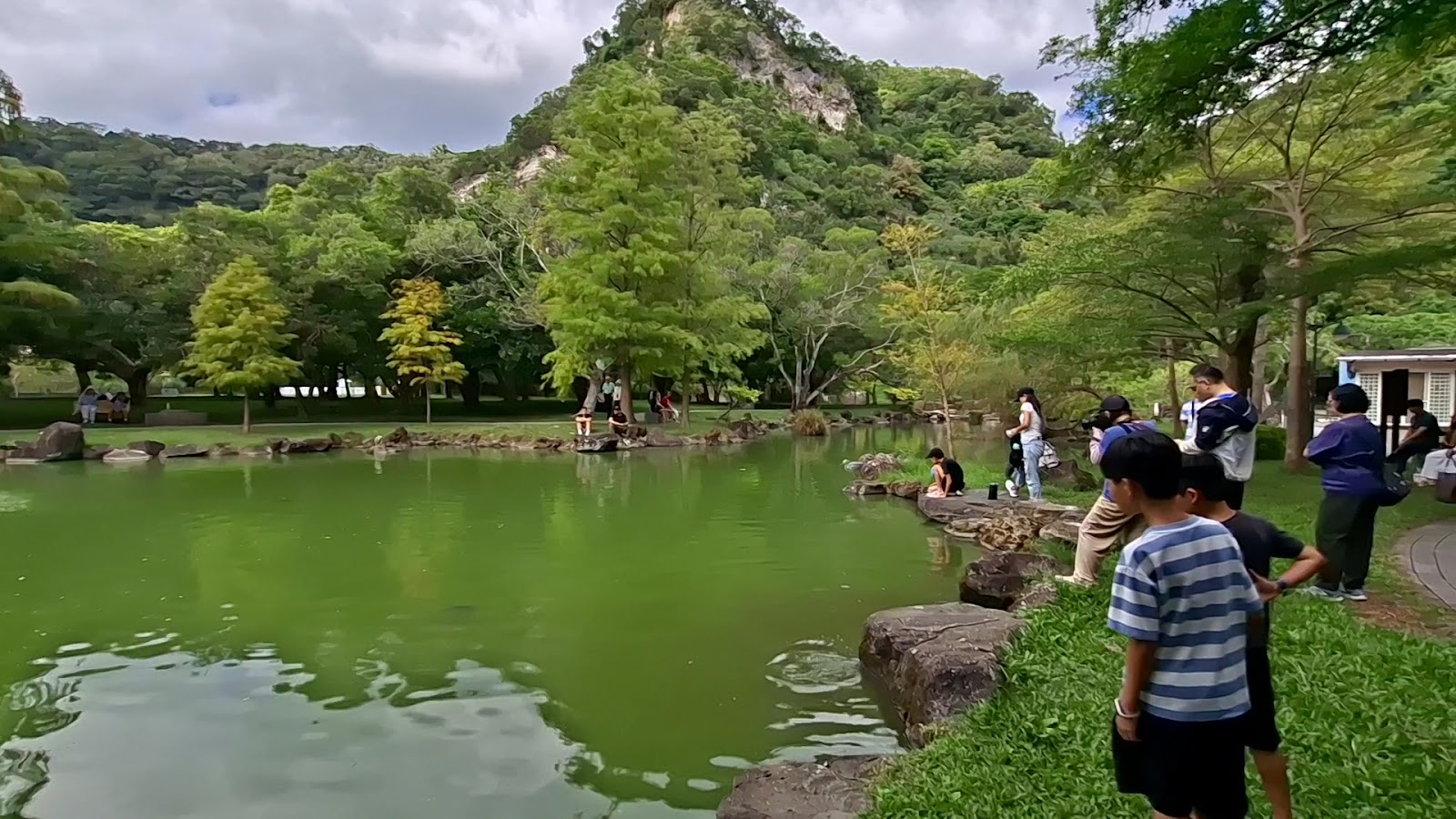 貴子坑水土保持教學園區情人湖畔遊客活動情形，多位遊客在湖邊步道散步觀察