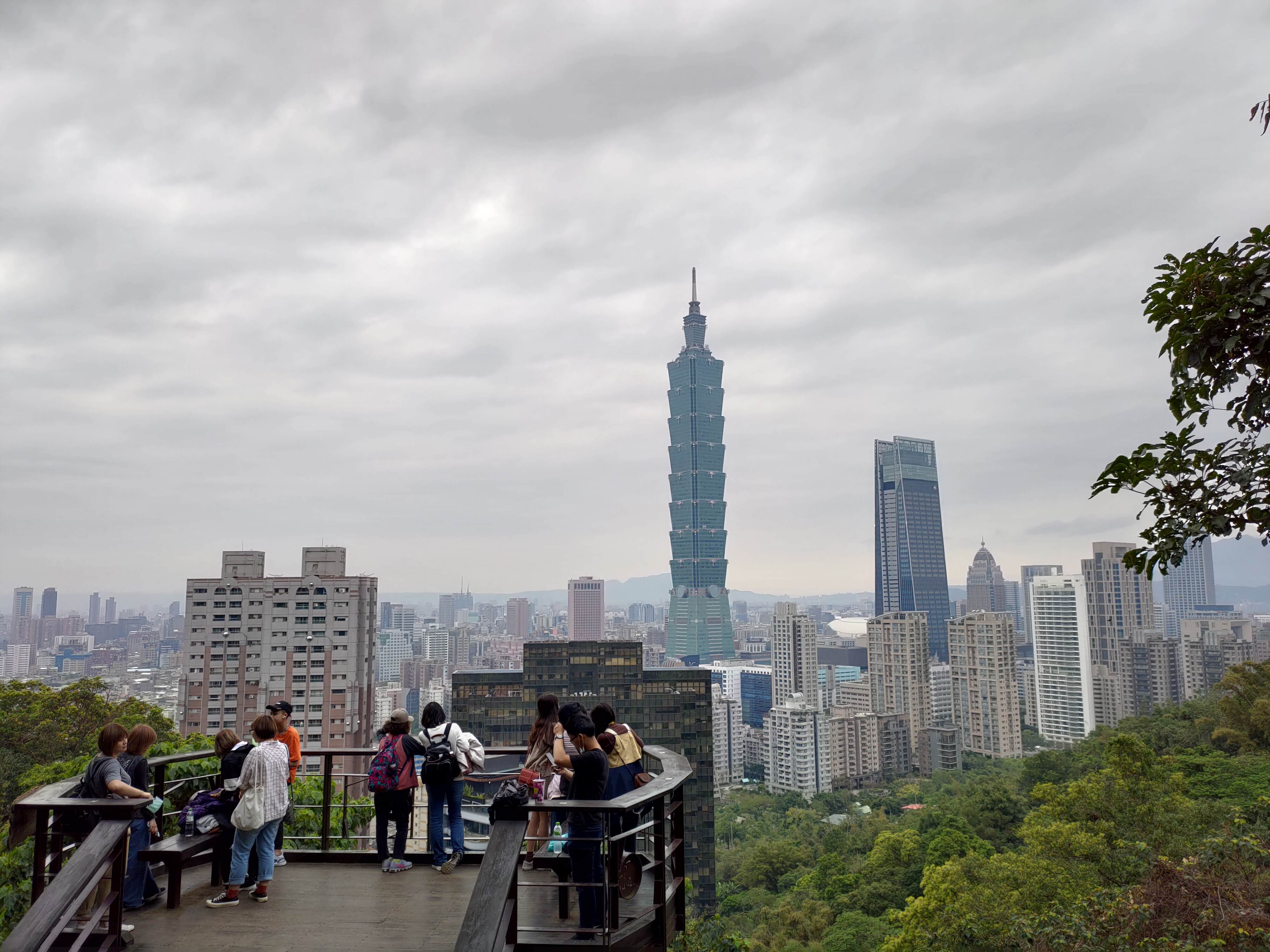 前景是一群人在觀景平台上欣賞城市風景。