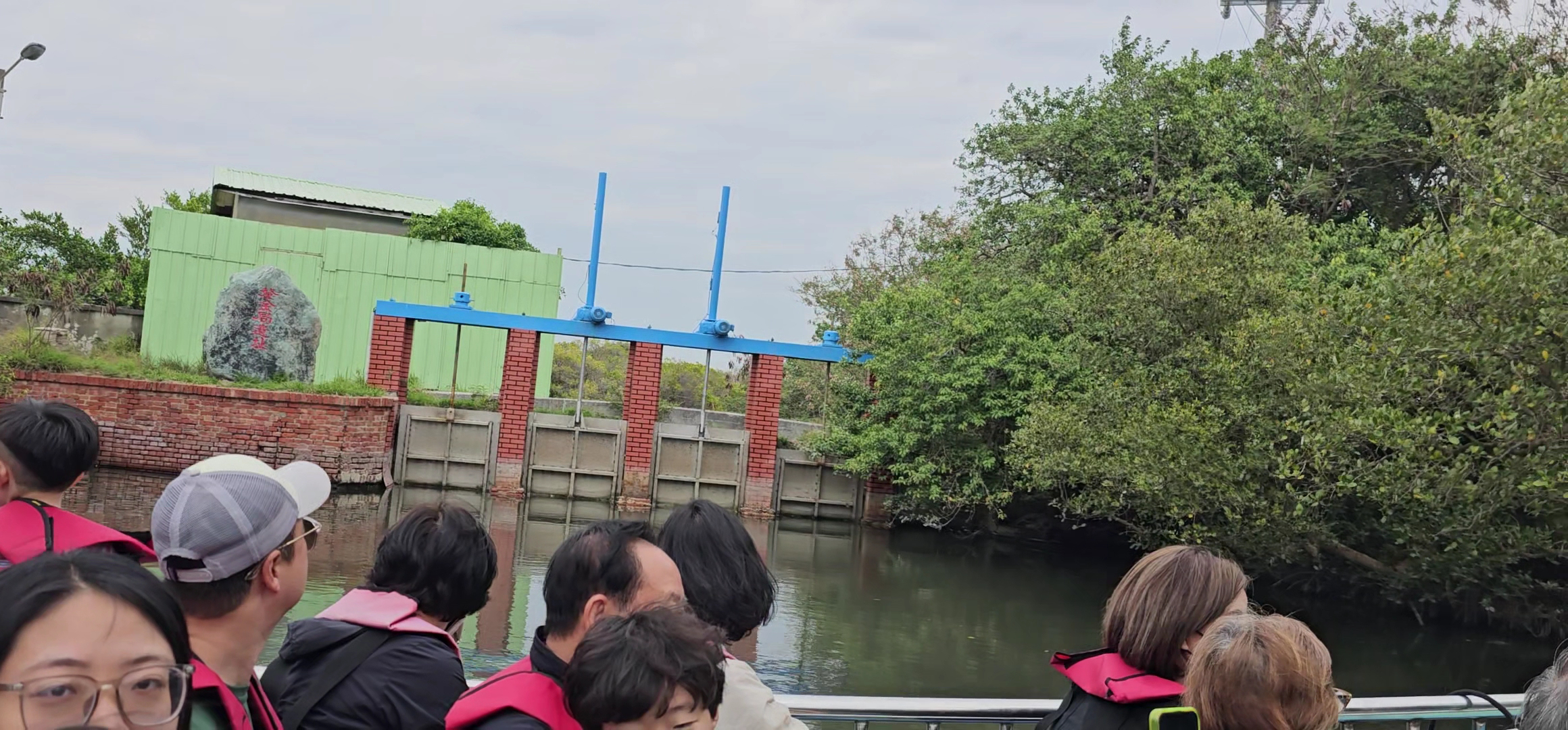 遊客穿著救生衣搭船經過水閘門