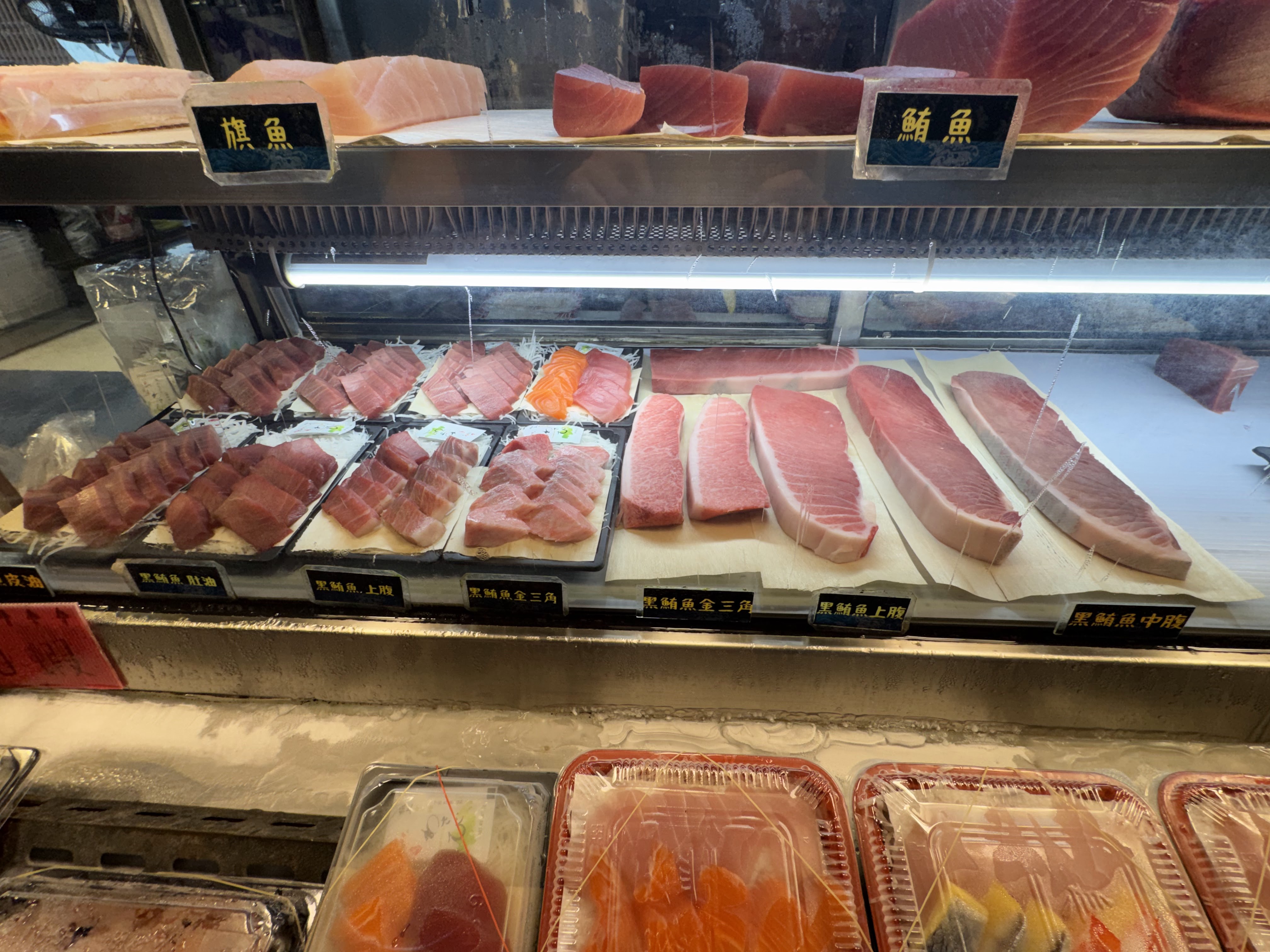 老程生魚片冷藏櫃,展示旗魚、鮪魚與黑鮪魚多種部位。