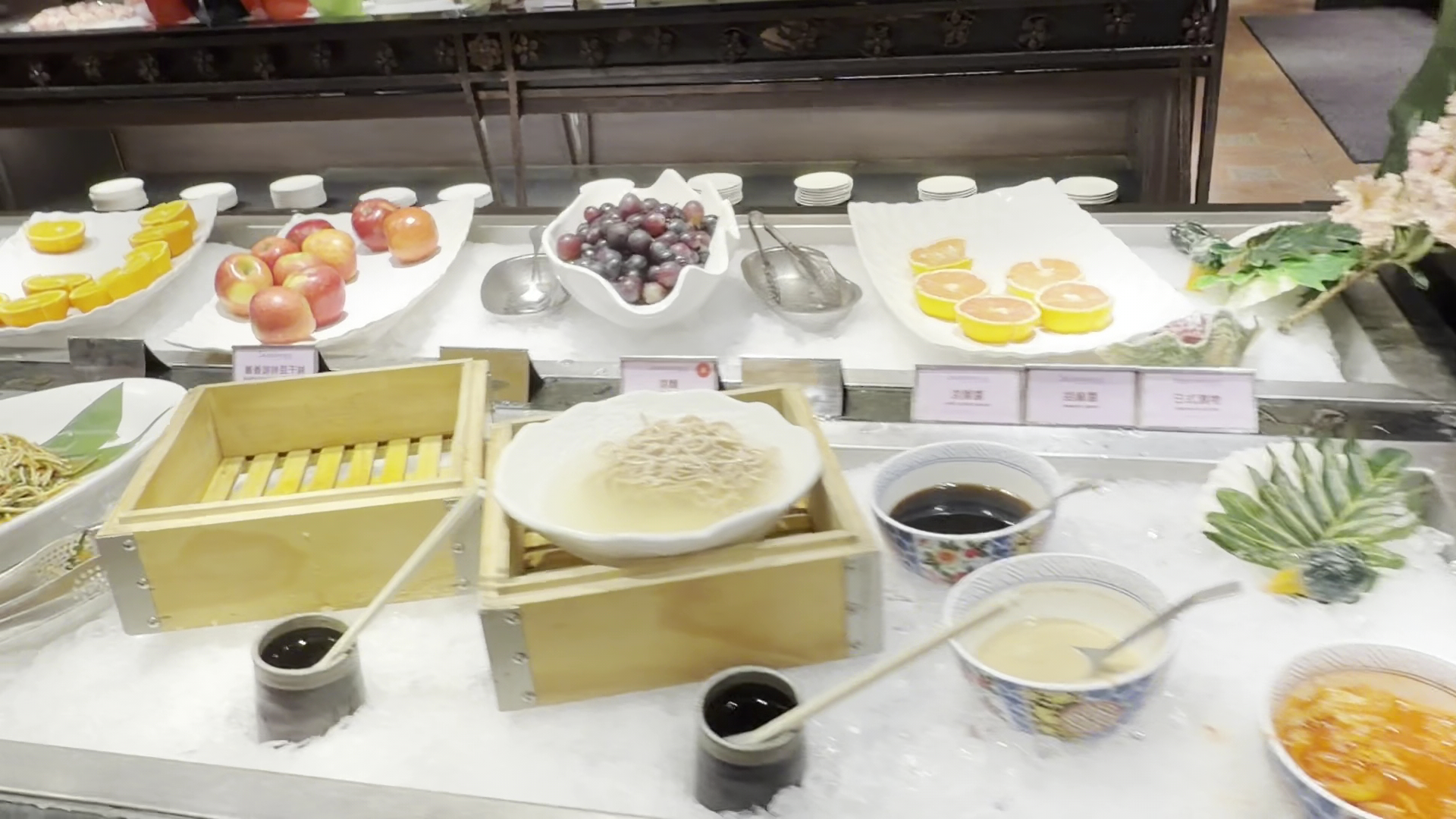 自助餐水果和涼麵區，有蘋果、葡萄、柳橙、柚子等水果及涼麵