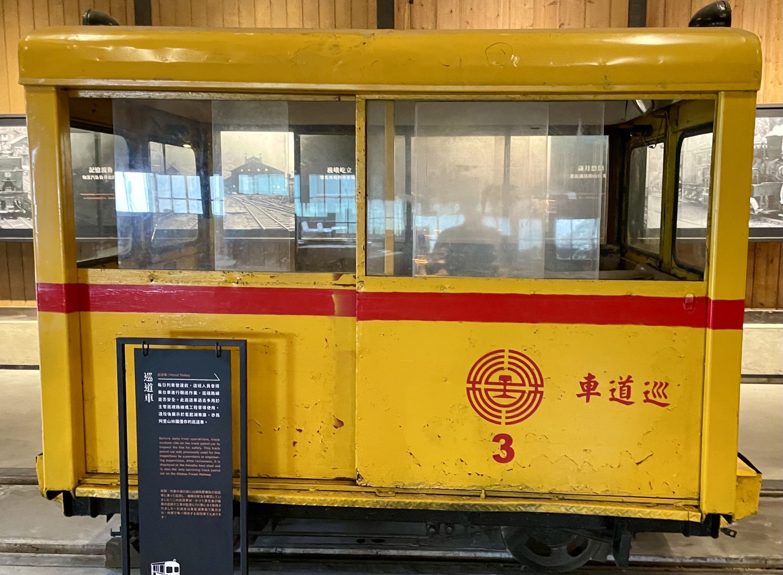 這張圖片主要是一輛黃色的巡道車,車身上標有紅色條紋和『車道巡3』字樣。旁邊有一個說明牌,介紹這輛巡道車的用途和歷史。圖片中沒有明顯的浮水印。