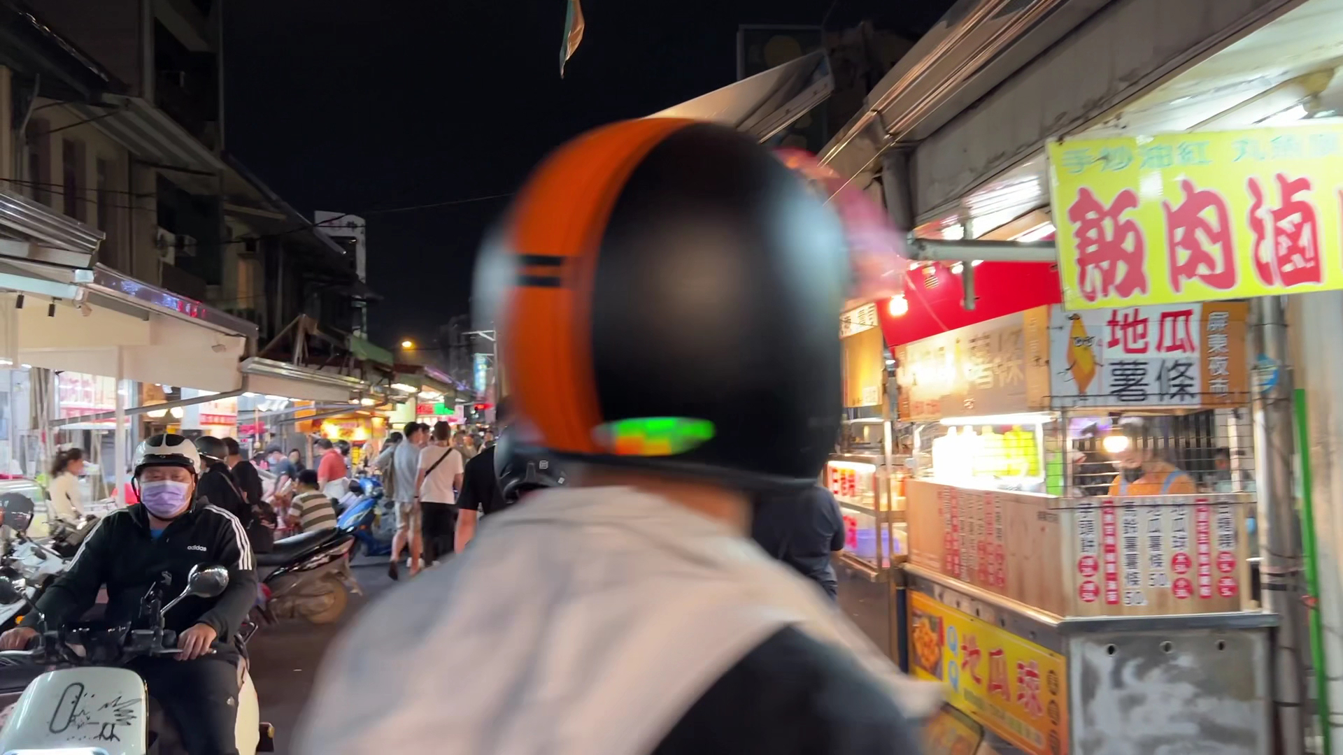 夜市裡有攤販、行人與機車共存的熱鬧夜景