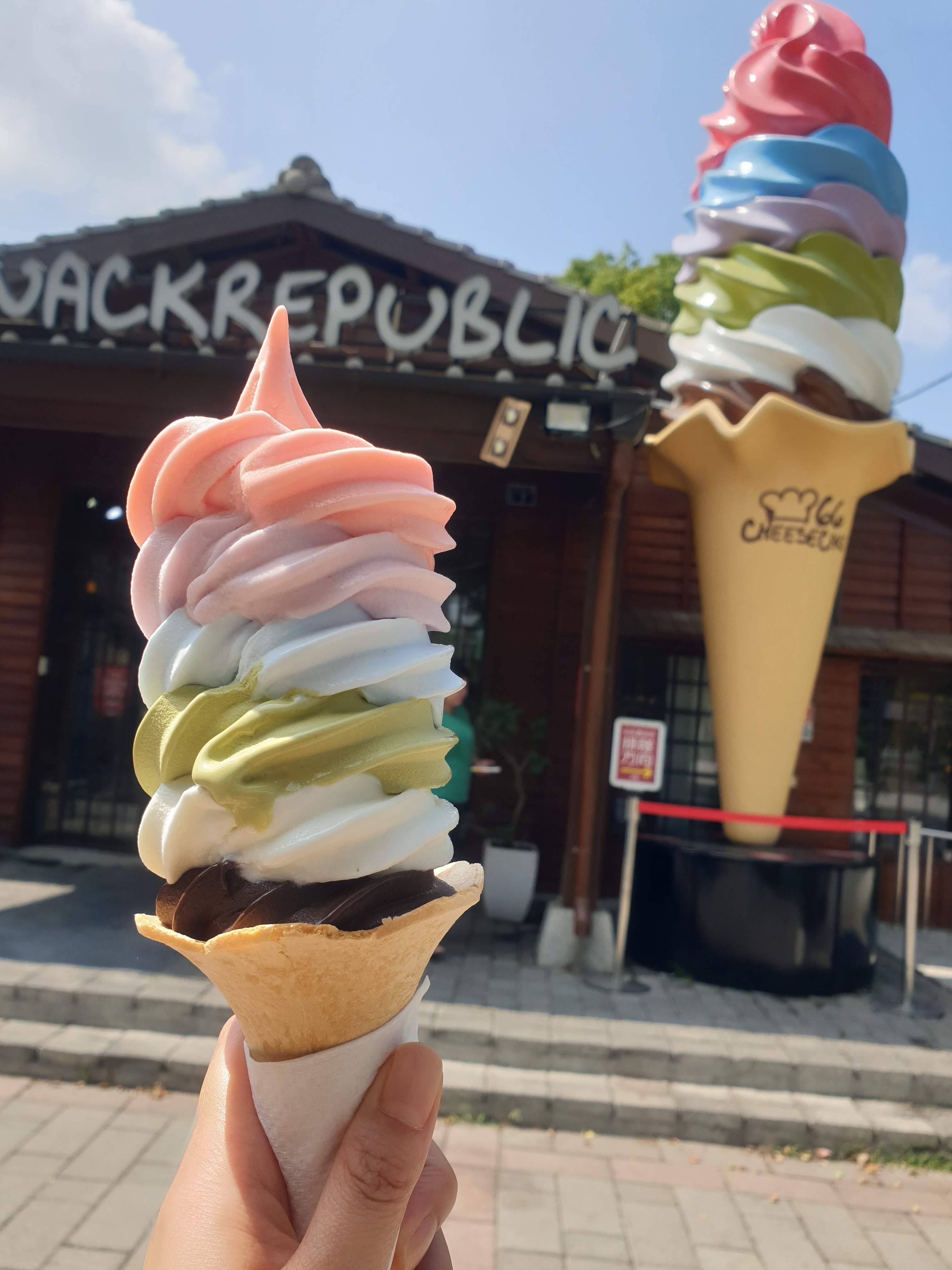 手持多層口味霜淇淋與店面背景
