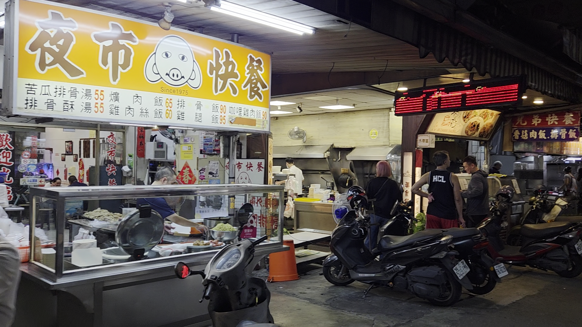 黃色招牌的夜市快餐店與排隊顧客