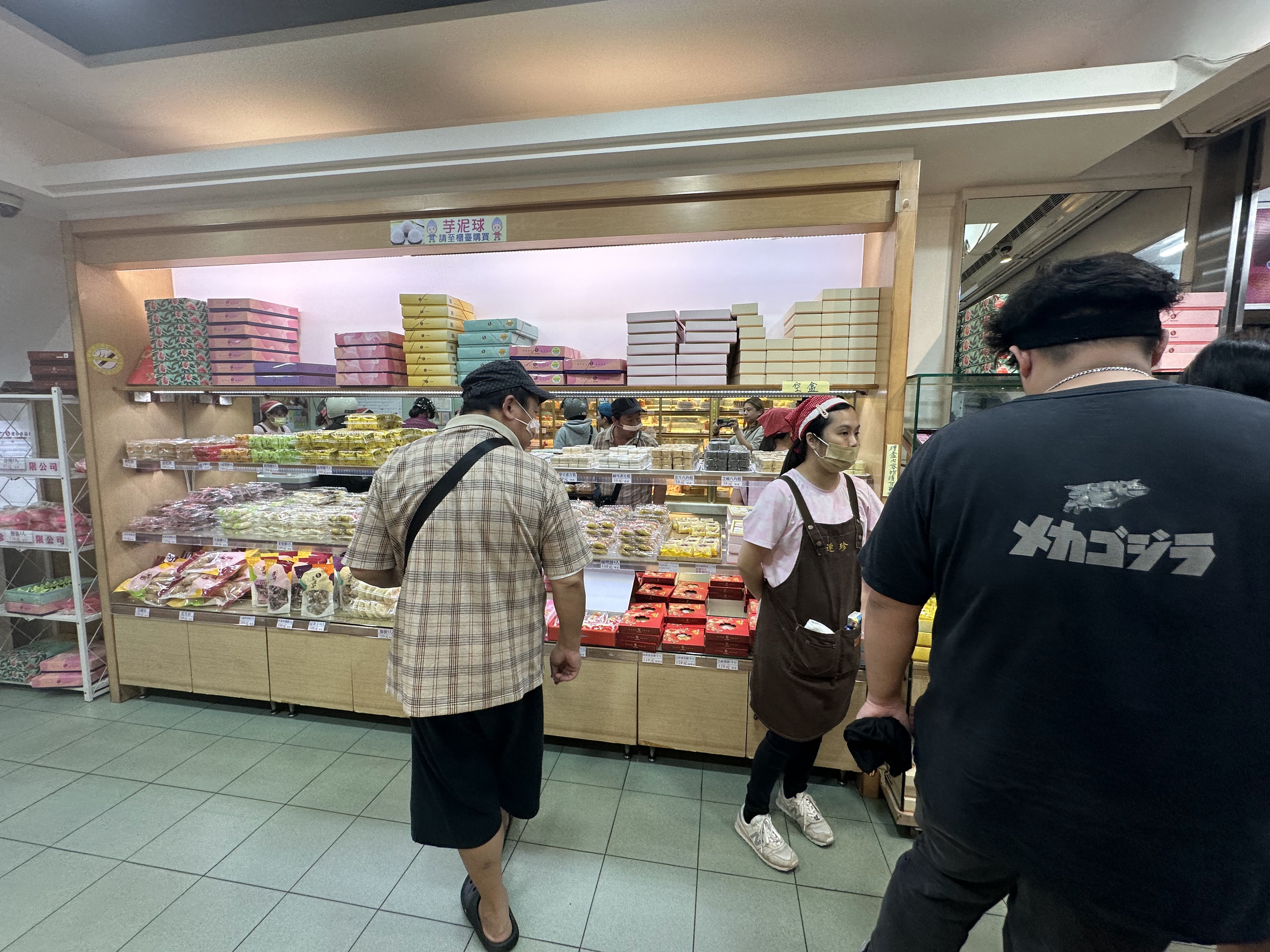 店員協助顧客挑選糕餅的店內畫面