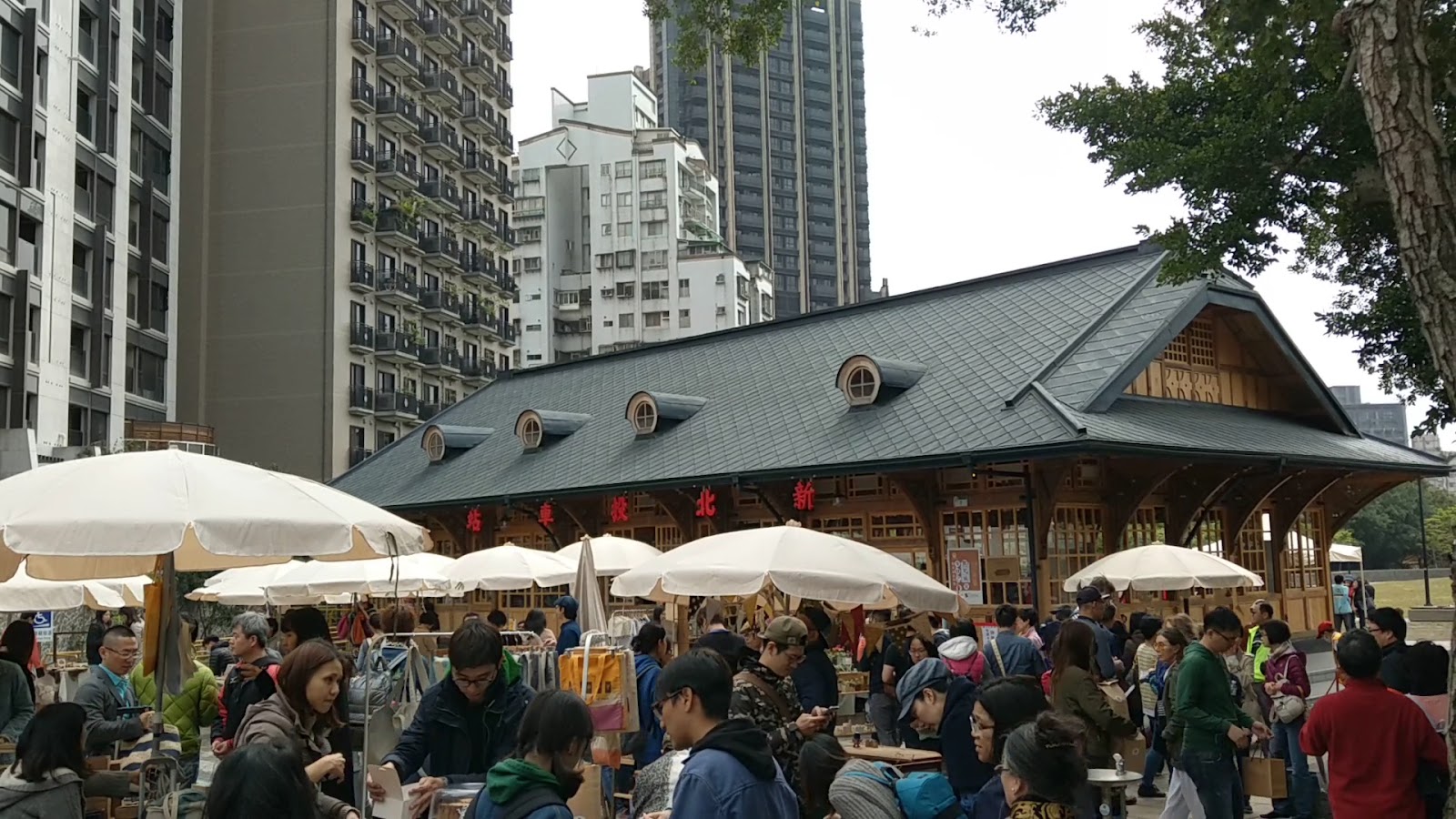 新北投車站木造外觀與站前市集洋傘人潮