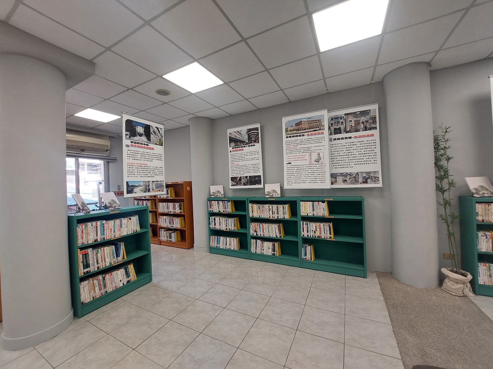 嘉義市立圖書館黃賓紀念圖書館一樓閱覽區,綠色與橘色書架整齊排列