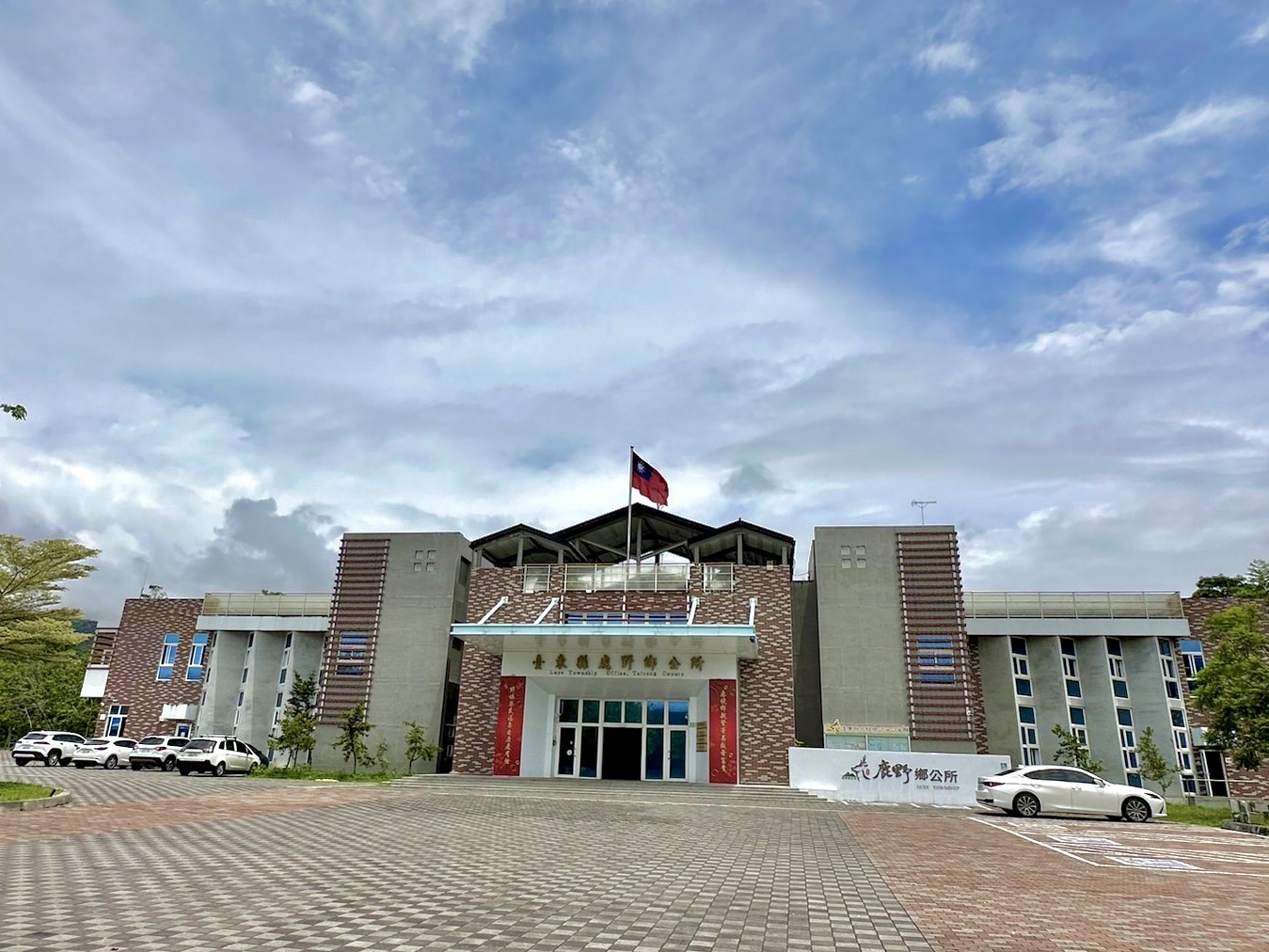 臺東縣鹿野鄉公所建築正面，紅磚與國旗相映，是巷弄生活圈的行政中心