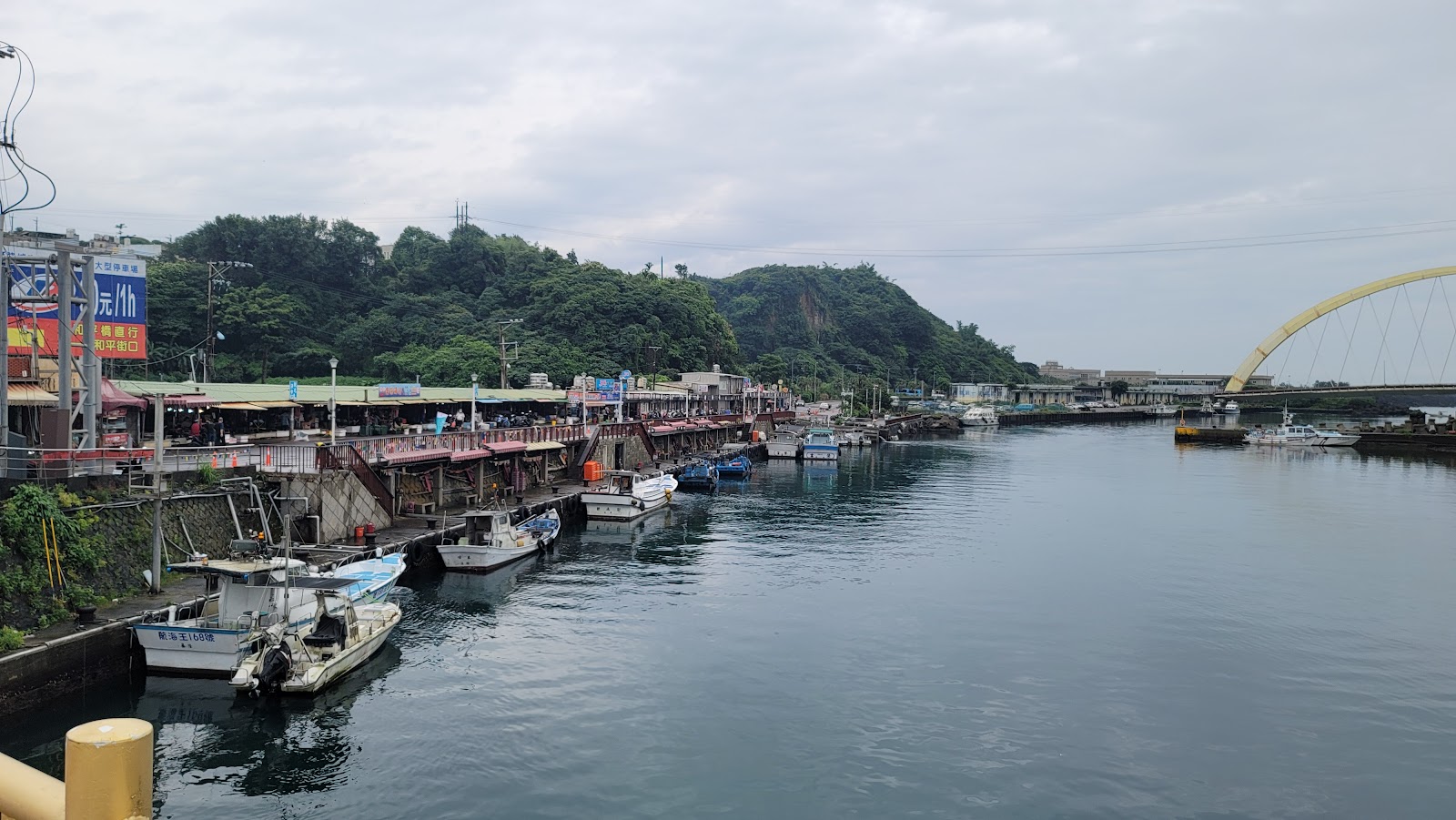 八尺門水道兩岸停滿漁船,遠方黃色和平橋橫跨其上