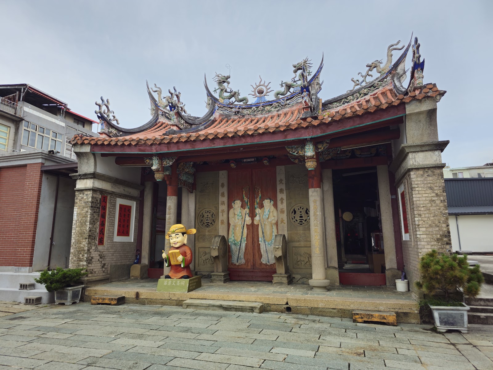 苗栗文昌祠正立面，燕尾飛簷屋脊與門前狀元公仔