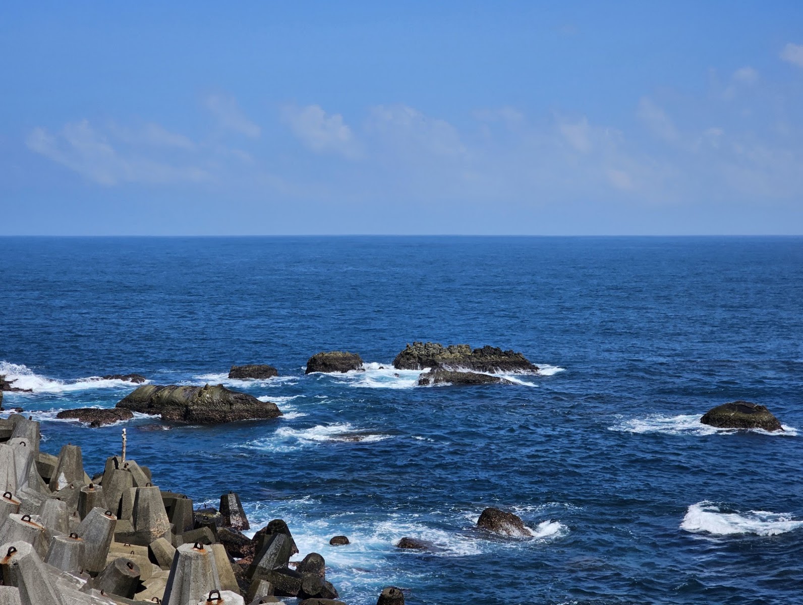 海面上多塊礁岩浪花拍打,河馬岩周邊海蝕地形