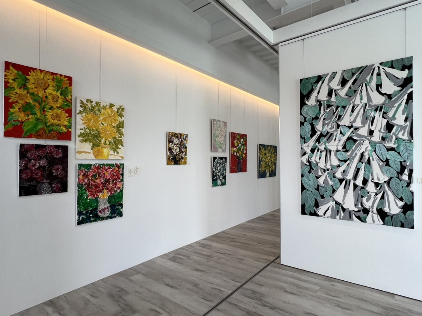 益品美術館展覽空間內,白牆上掛滿館主的油畫創作