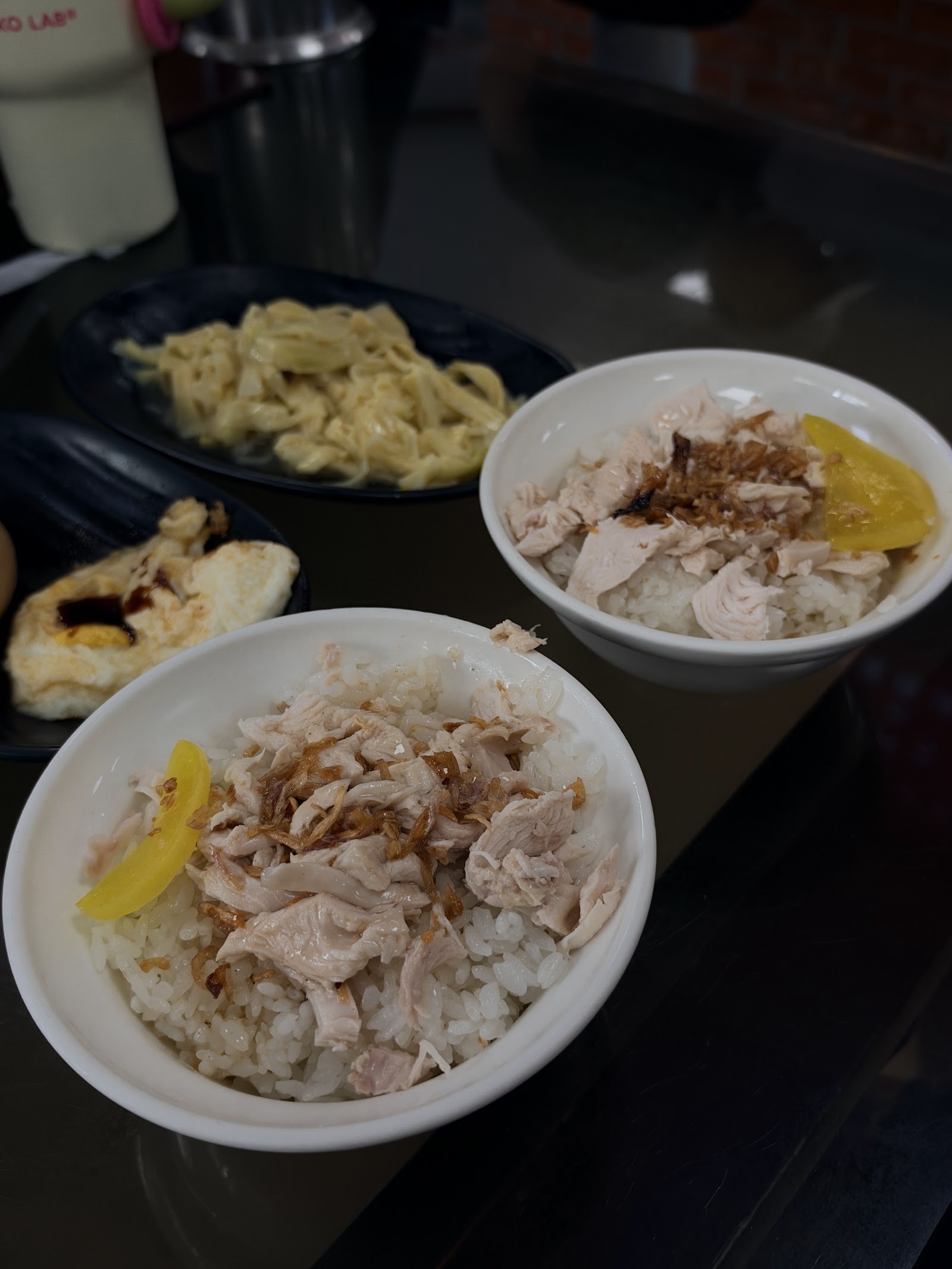 兩碗光華阿宏火雞肉飯特寫俯拍,淋醬油與油蔥酥,配滷蛋滷豆包