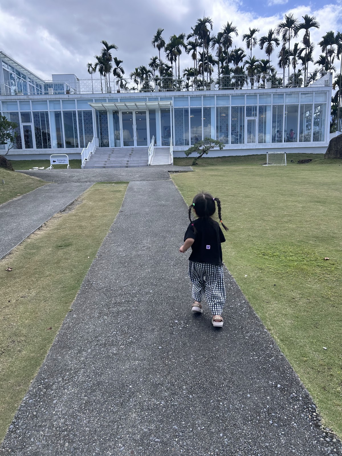 純白玻璃屋建築外觀,搭配開闊草坪與步道