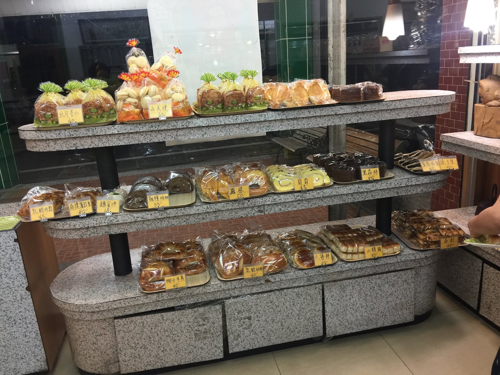 金名城麵包店三層陳列櫃，多款麵包蛋糕一字排開