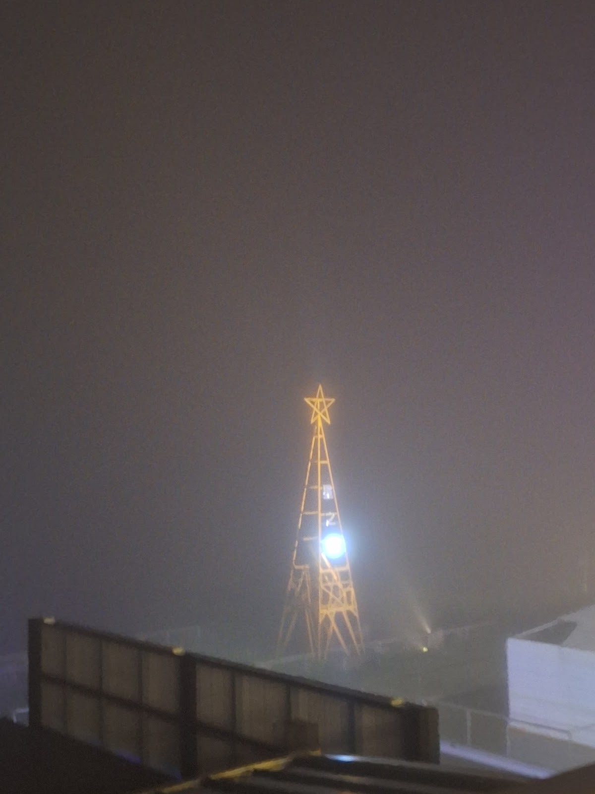 霧夜中發光的五角星造型觀景塔剪影