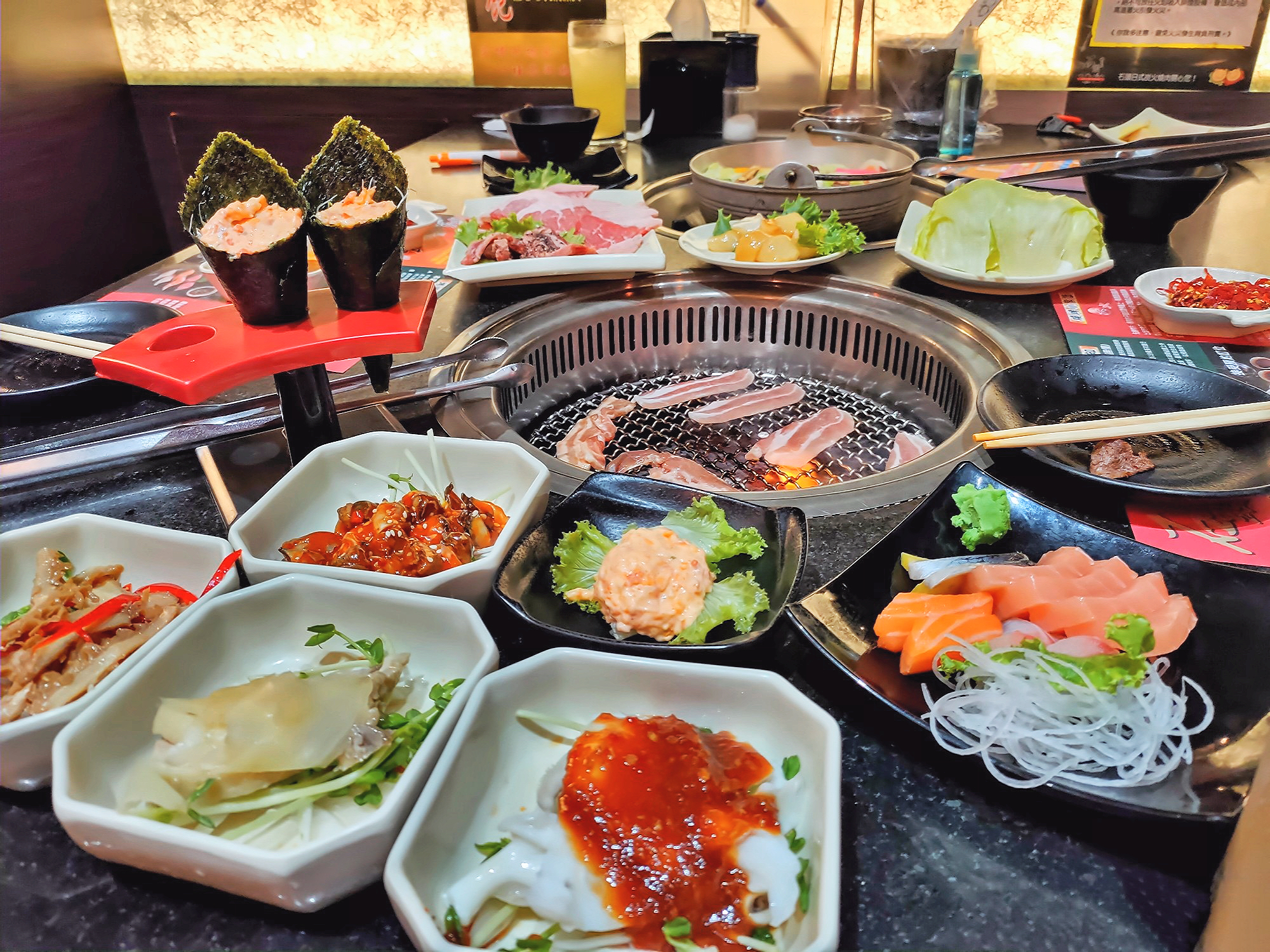 日式燒烤餐桌上有手卷生魚片與烤肉