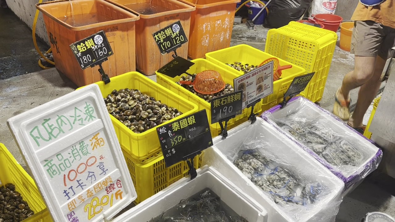 市場中展示泰國蝦蛤蜊東石鮮蚵等海鮮並標示價格