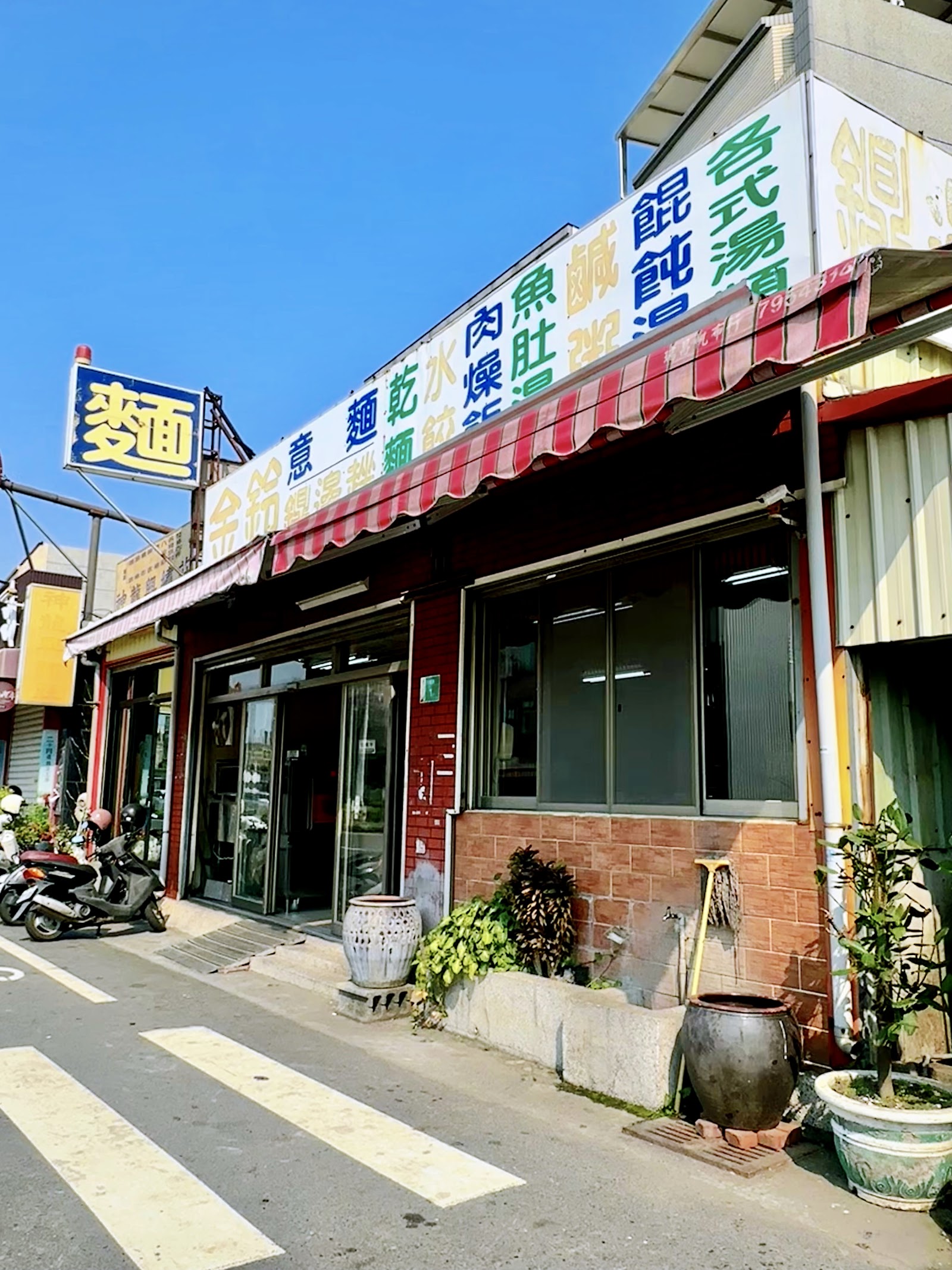 金鈴意麵店面招牌外觀,藍天白牆經典小吃店