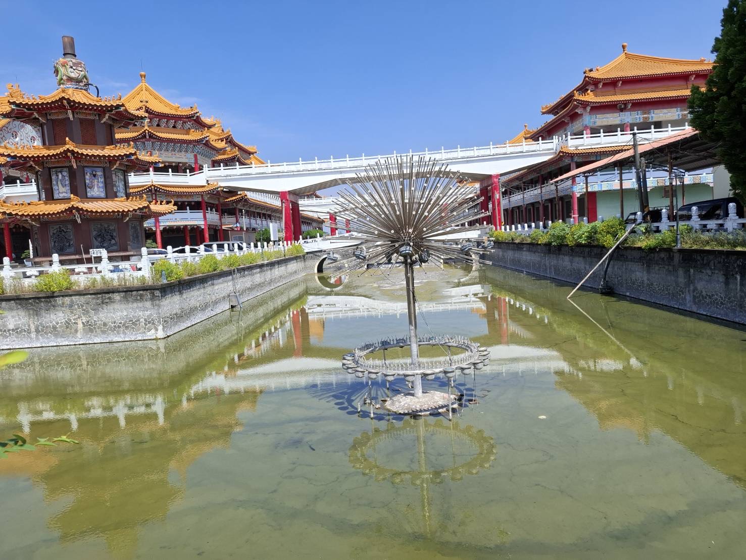 鹿耳門天后宮後方水池倒影景觀，蓮花狀金屬雕塑與遠方塔樓倒映水面