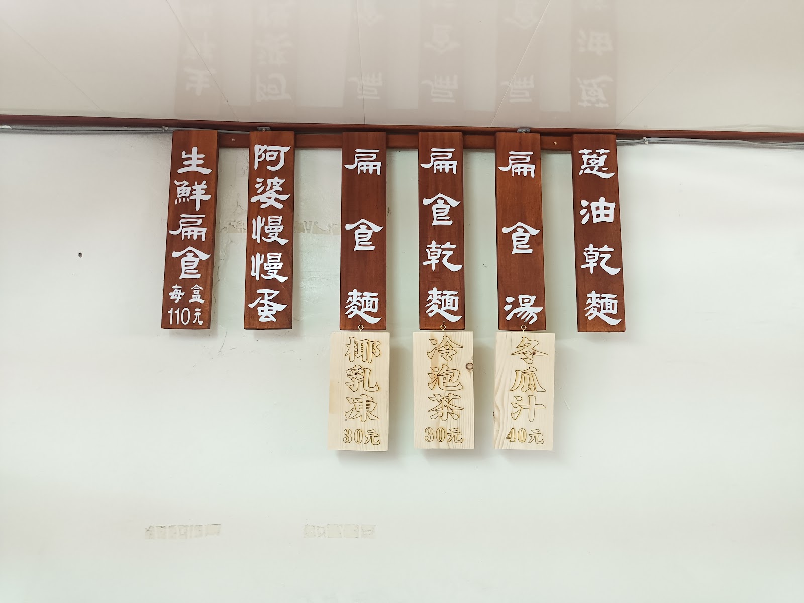 阿婆慢慢麵木製菜單招牌，扁食麵與招牌滷蛋品項