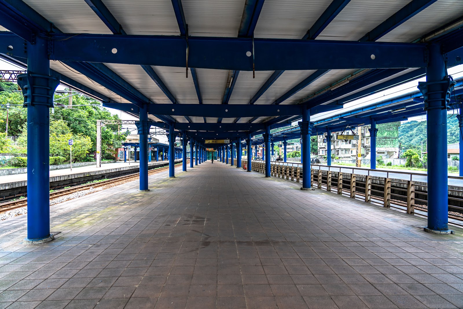 八堵車站-八堵車站月台空景,藍色鋼構雨棚沿鐵道延伸
