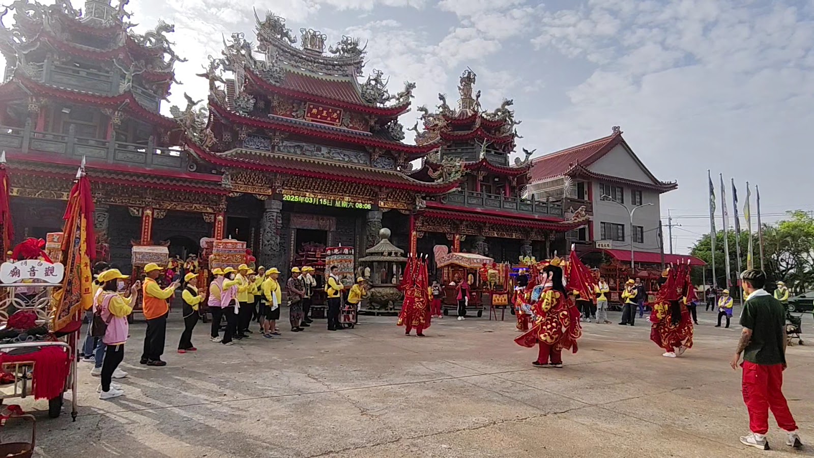白河觀音廟廟埕繞境活動,信眾著黃背心排班,陣頭紅袍神將氣勢十足