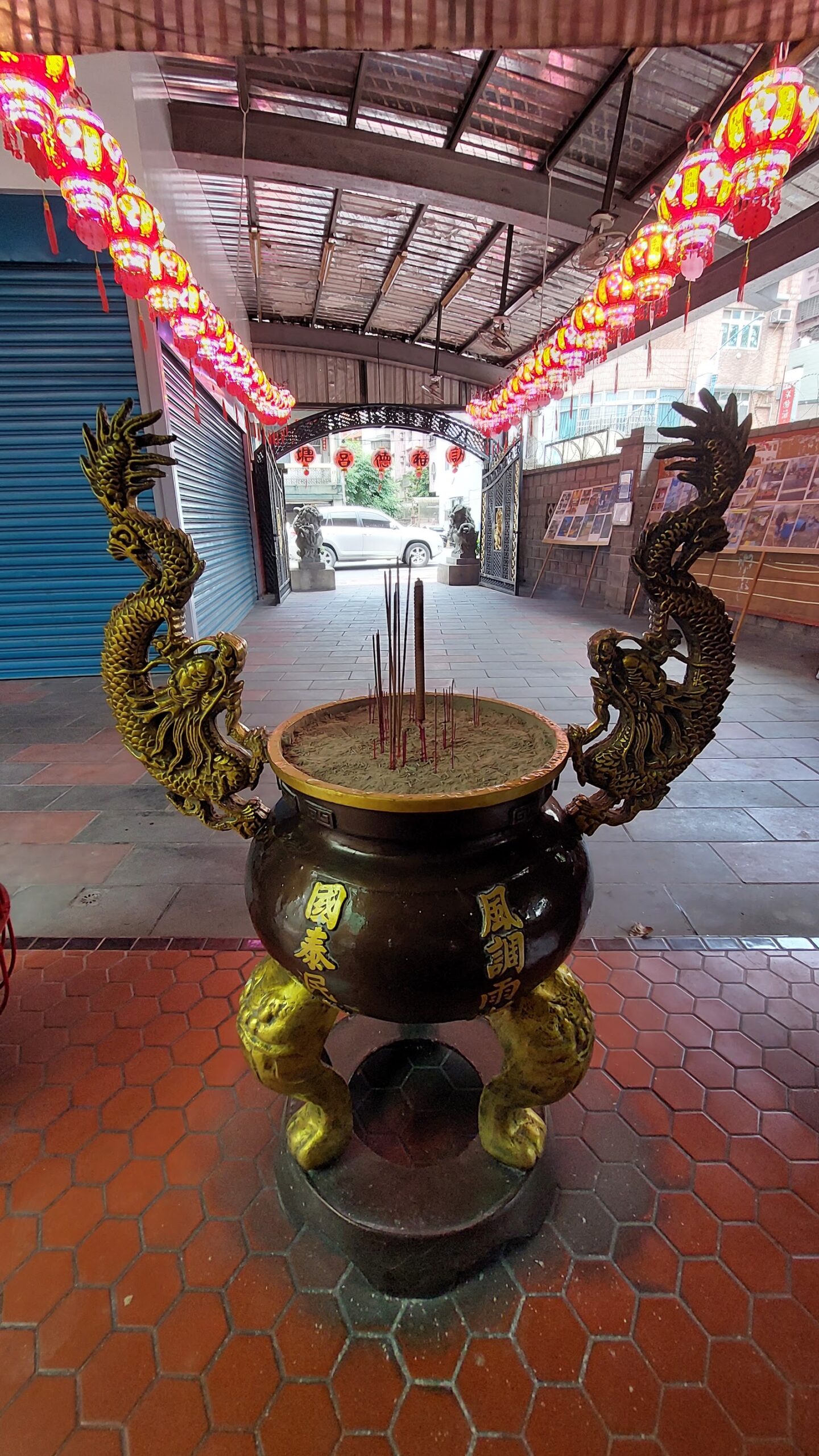 八里福德宮龍耳大香爐特寫,香煙裊裊,背景紅燈籠走廊與石獅