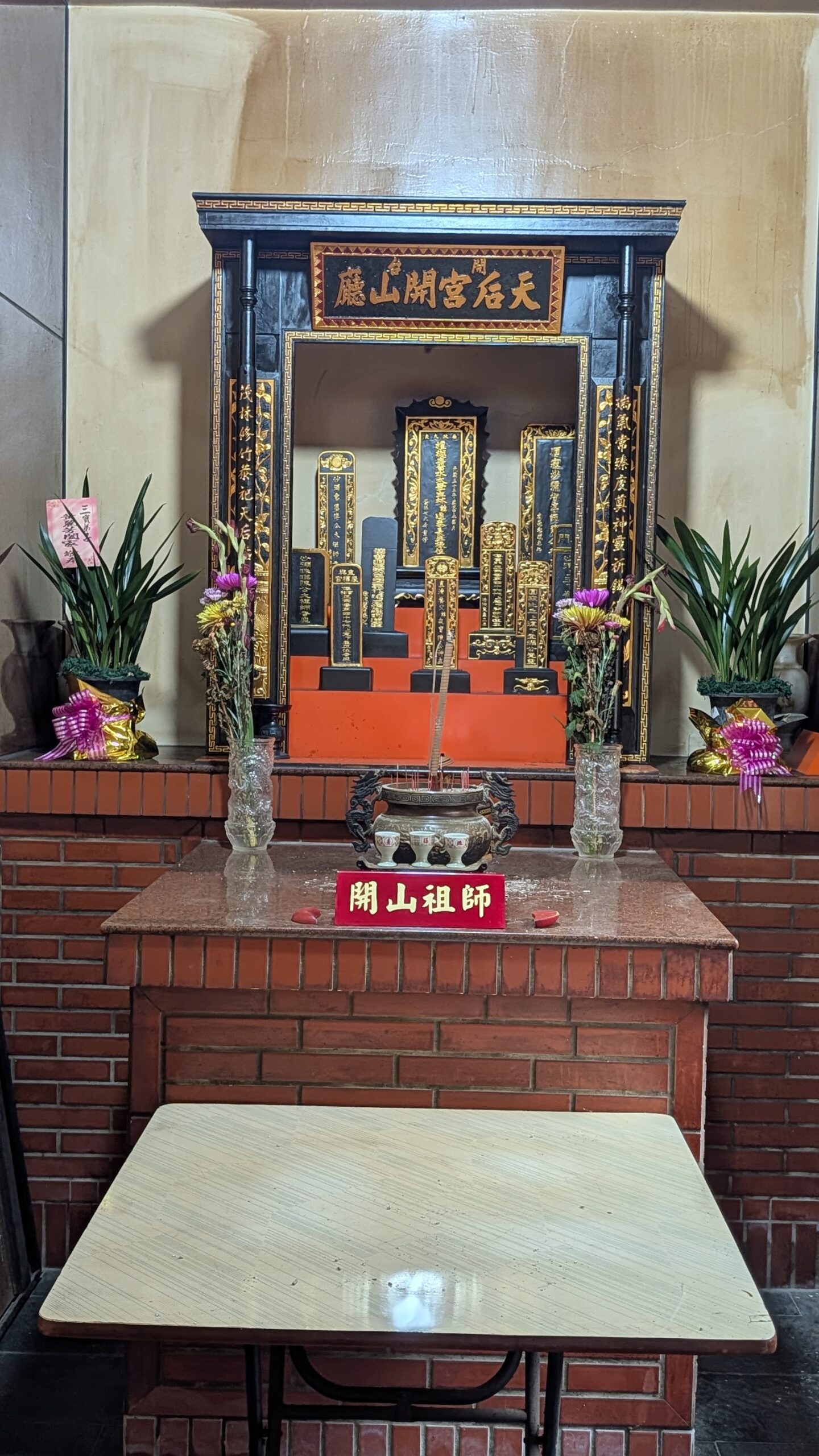 八里開臺天后宮開山祖師神龕特寫,紅磚供桌與摺疊桌