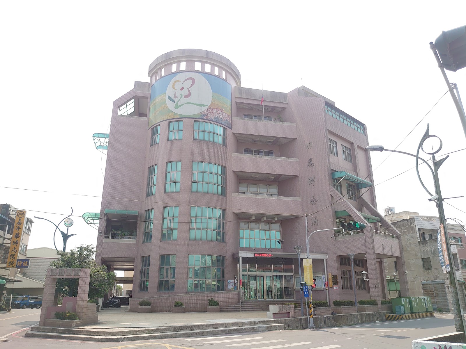 彰化田尾鄉公所外觀，圓弧轉角建築與花卉意象看板